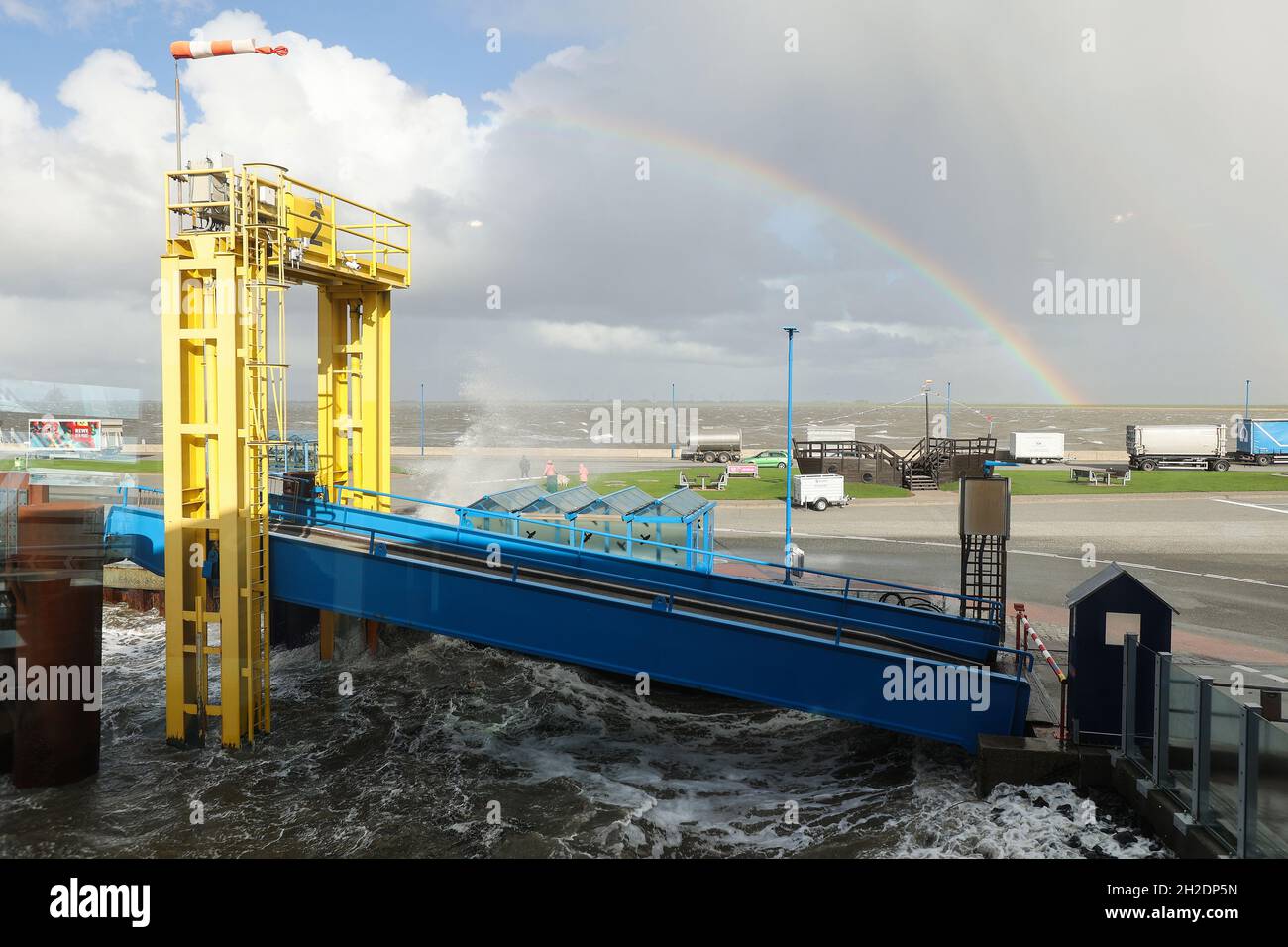21 octobre 2021, Schleswig-Holstein, Dagebüll: Un arc-en-ciel est vu à l'embarcadère du ferry à Dagebüll au fur et à mesure que le niveau de la mer du Nord monte.Le bas 'Ignatz' se déplace au-dessus du Schleswig-Holstein jeudi.Photo: Bodo Marks/dpa Banque D'Images