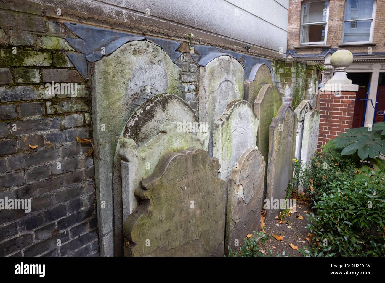 Pierres anciennes du XVIIIe siècle à côté du Mémorial de Watts à Heroic Self sacrifice dans Postman's Park à Londres EC1 Banque D'Images