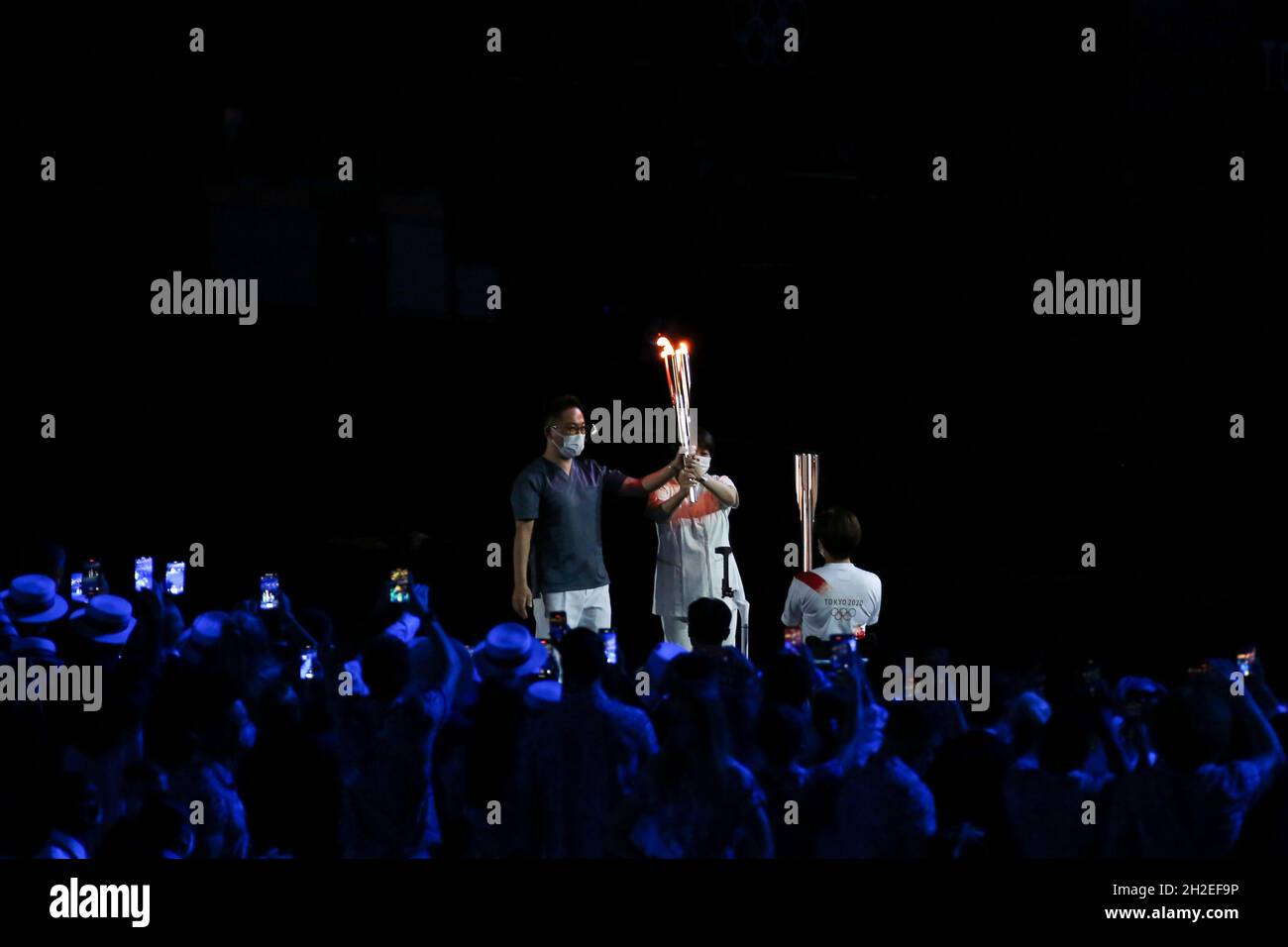 23 JUILLET 2021 - TOKYO, JAPON: La flamme olympique portée par le docteur japonais Hiroki OOHASHI et l'infirmière Junko KITAGAWA est transmise au paralympique Wakako T. Banque D'Images