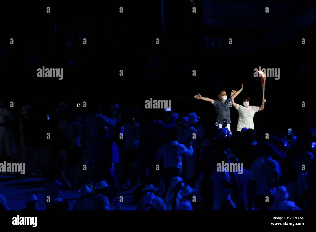 23 JUILLET 2021 - TOKYO, JAPON: La flamme olympique est portée par le médecin japonais Hiroki OOHASHI et l'infirmière Junko KITAGAWA pendant le Ceremon d'ouverture Banque D'Images