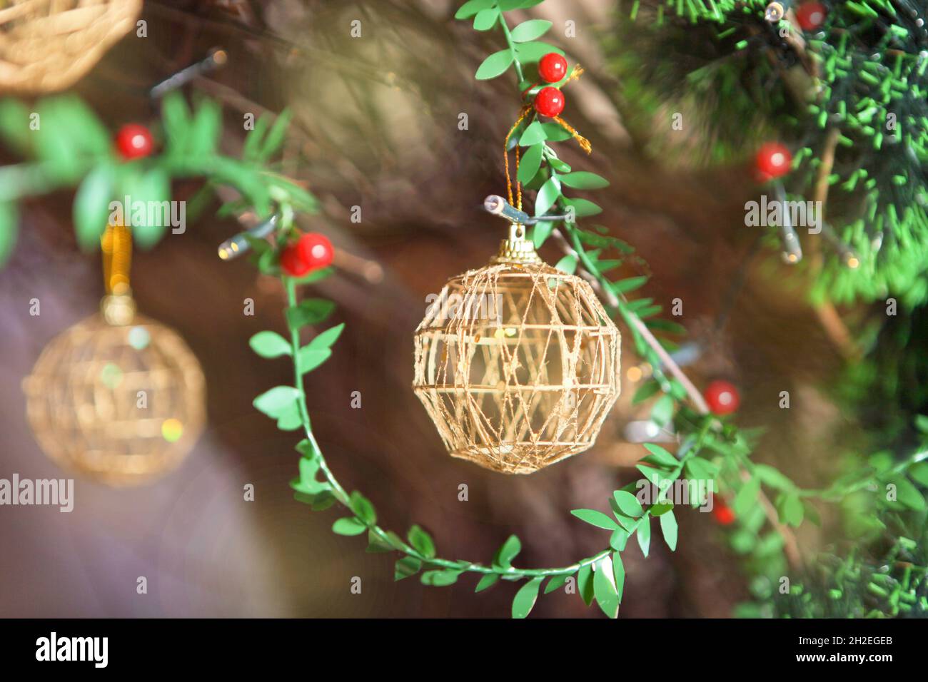 boules de noël dorées sur sapin en plastique vert.Décoration de Noël dorée sur l'arbre de Noël Banque D'Images
