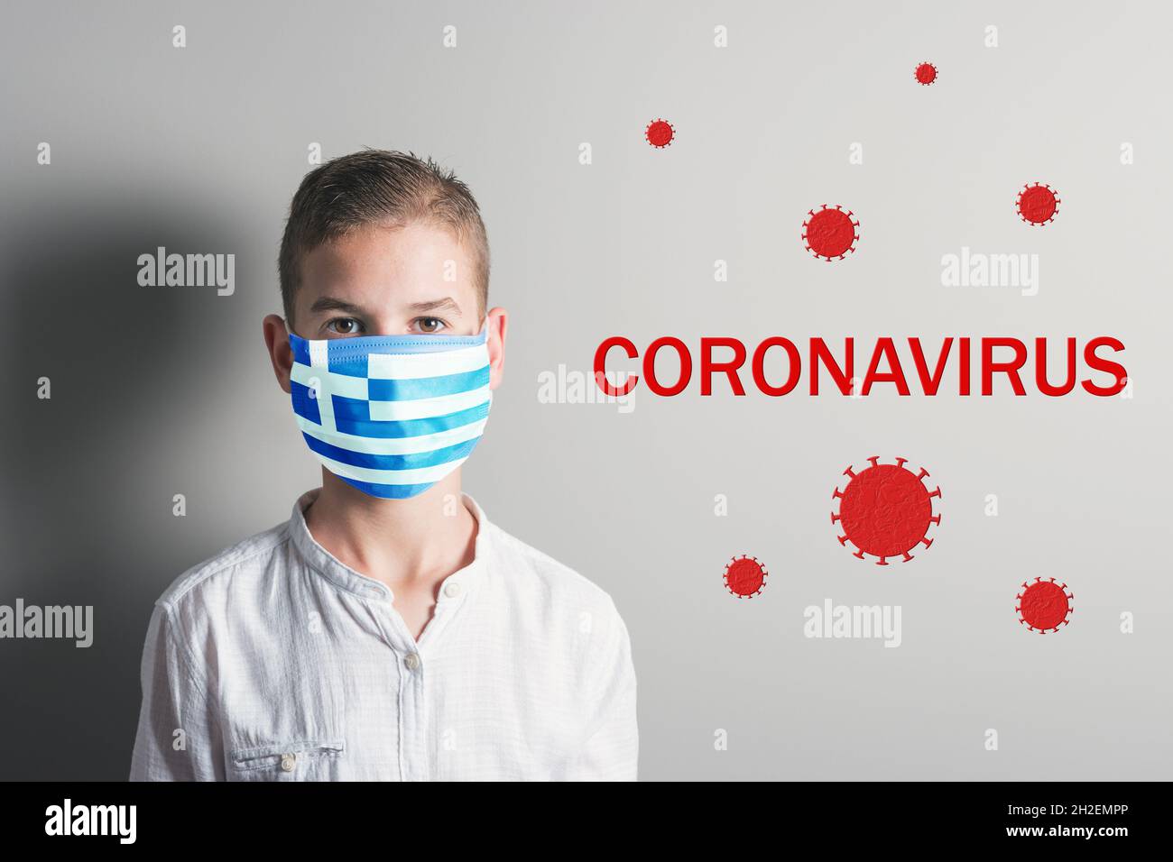 Garçon dans un masque médical avec le drapeau de la Grèce sur son visage sur fond clair. Virus épidémique 2019-nCoV syndrome respiratoire. Concept de médecine. Banque D'Images