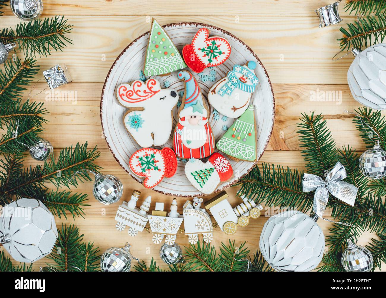 Pain d'épice de Noël, biscuits sur une table en bois naturel à côté des branches de sapin.Flocons de neige, bonhomme de neige, cerf, biscuits du Père Noël.Maquette du nouvel an Banque D'Images