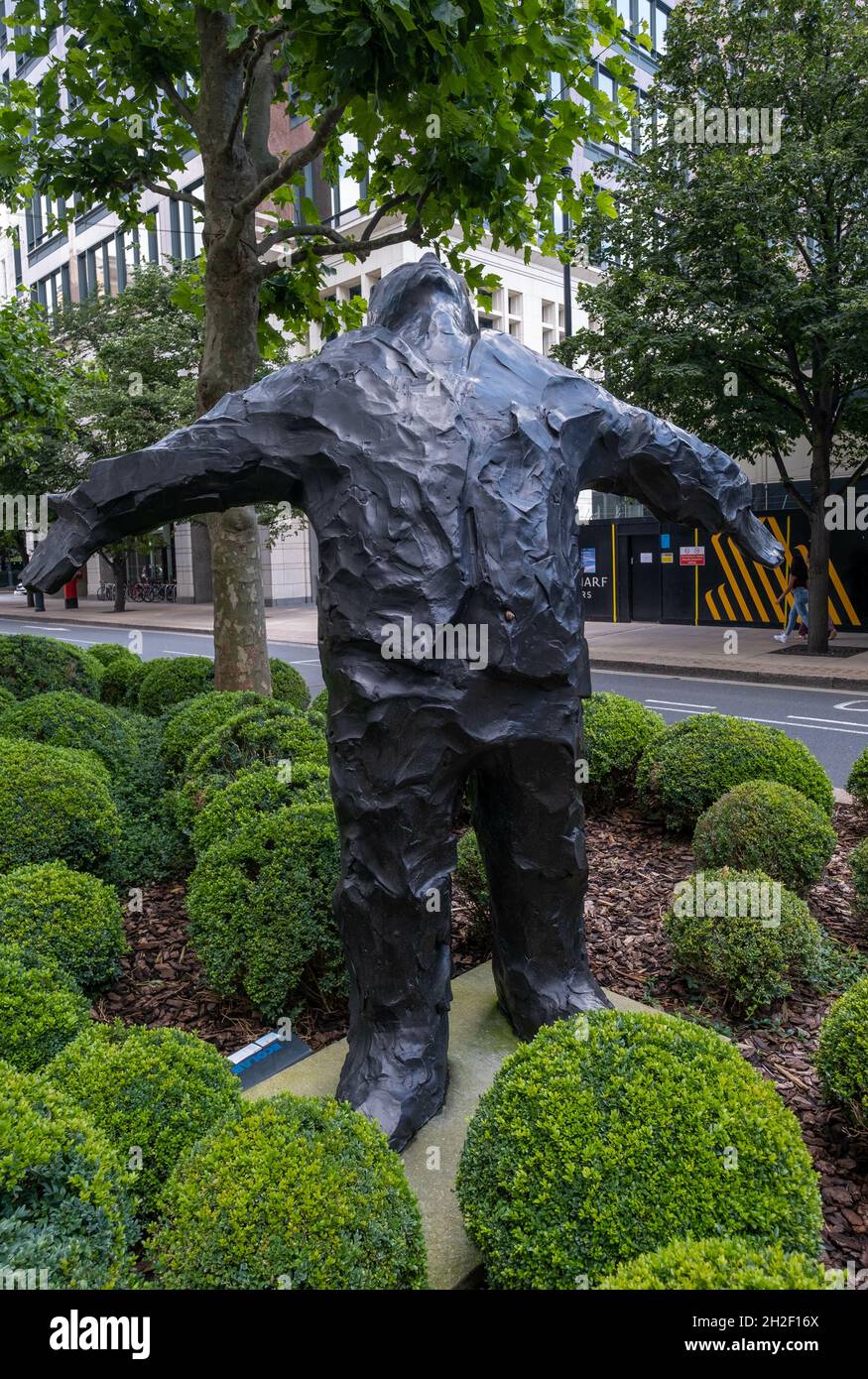 LONDRES, ROYAUME-UNI - 10 août 2021 : un cliché vertical d'une sculpture d'un homme à bras ouverts par Giles Penny à Canary Wharf, Londres, Royaume-Uni Banque D'Images