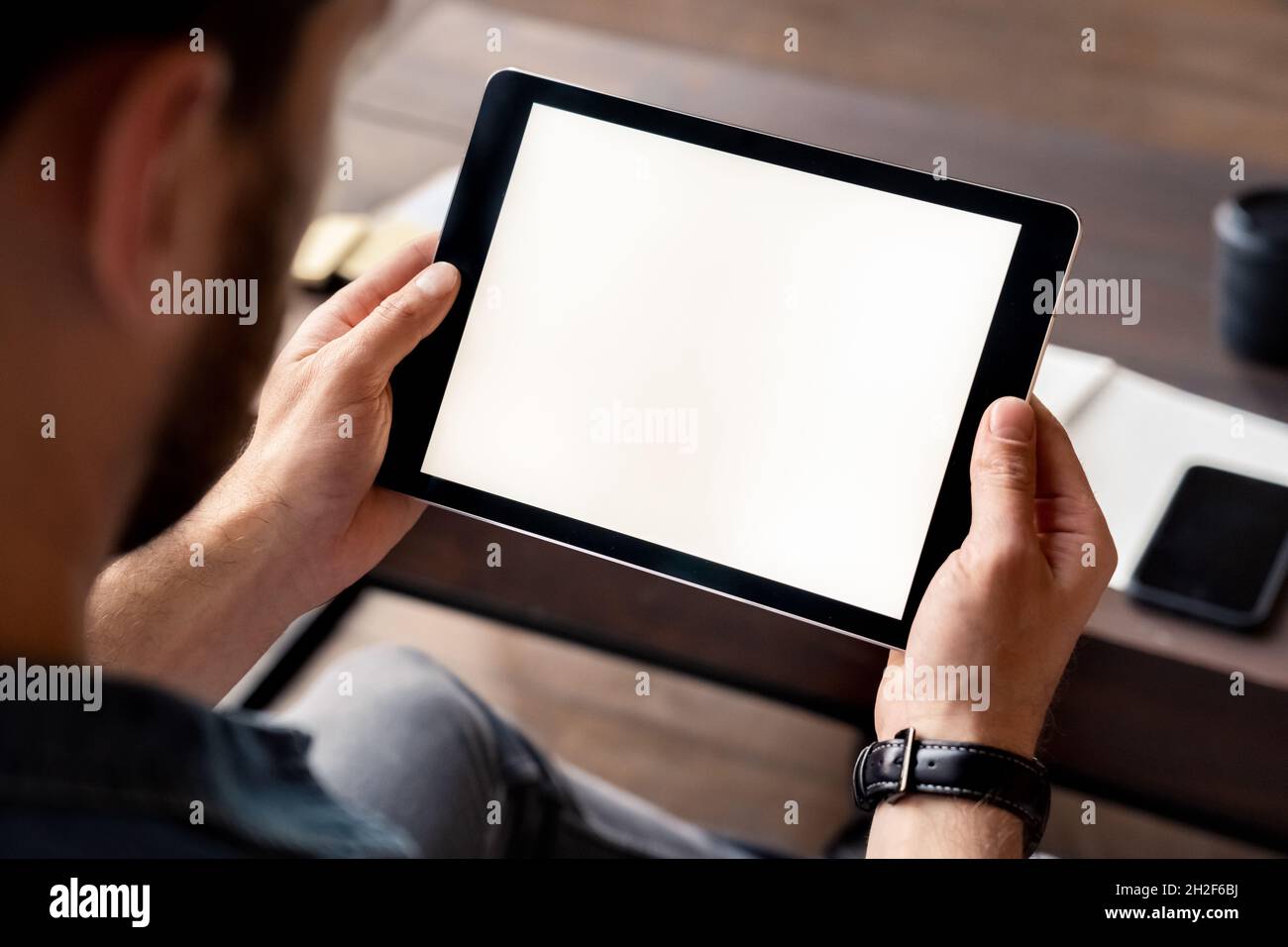 Homme tenant l'écran blanc de la tablette numérique dans la vue à la main au-dessus de l'épaule Banque D'Images