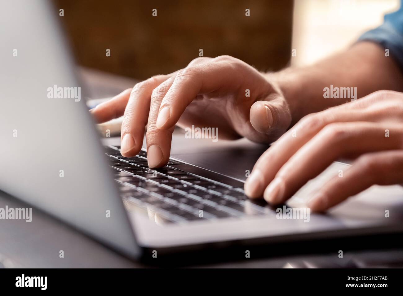 Gros plan sur la saisie manuelle masculine sur le clavier d'ordinateur portable sur le lieu de travail Banque D'Images