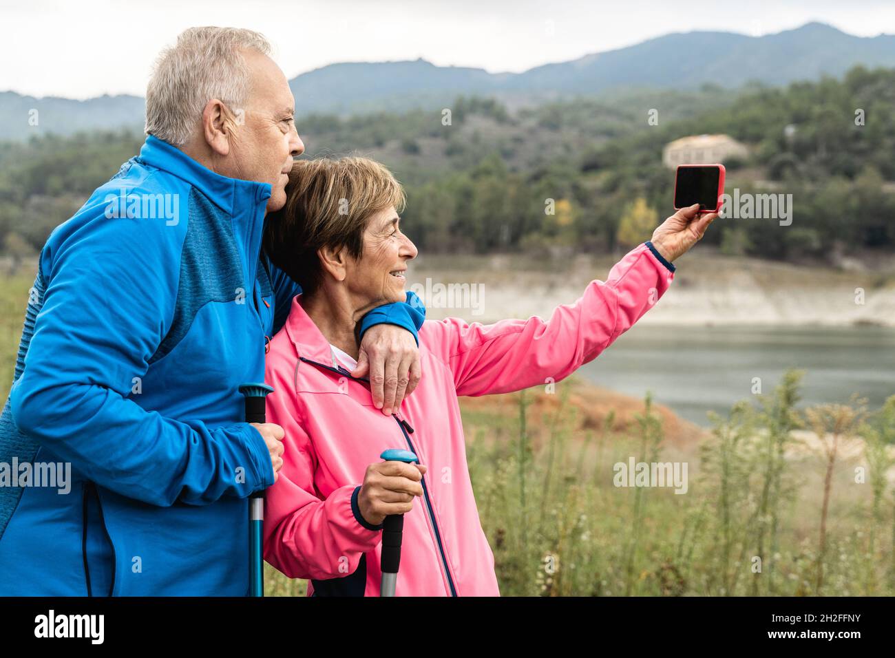 Couple senior heureux ayant l'amusement de prendre un selfie randonnée dans les bois - Focus sur le visage de femme Banque D'Images