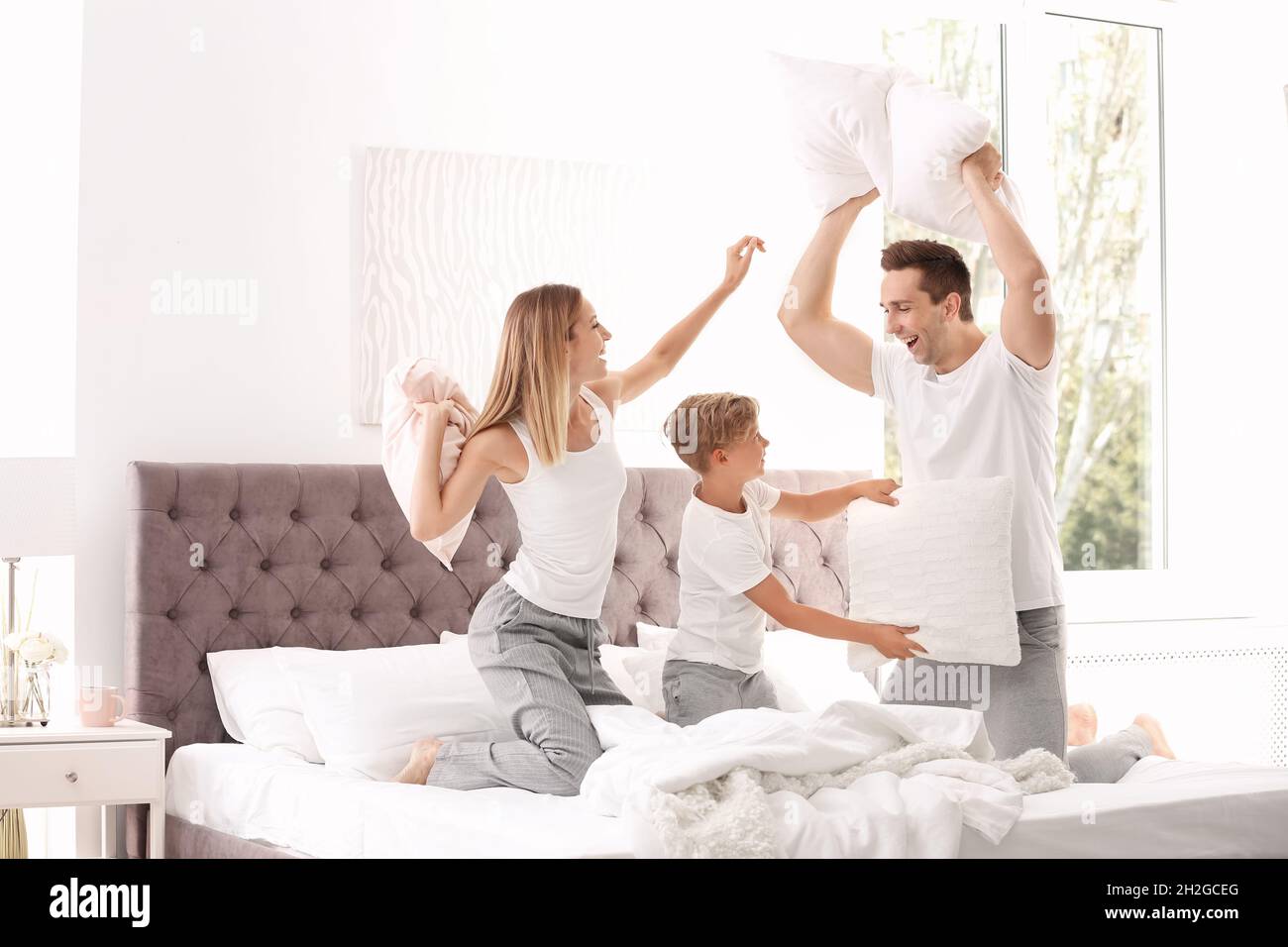 Une famille heureuse avec un matelas à plateau-coussin à la maison Photo  Stock - Alamy