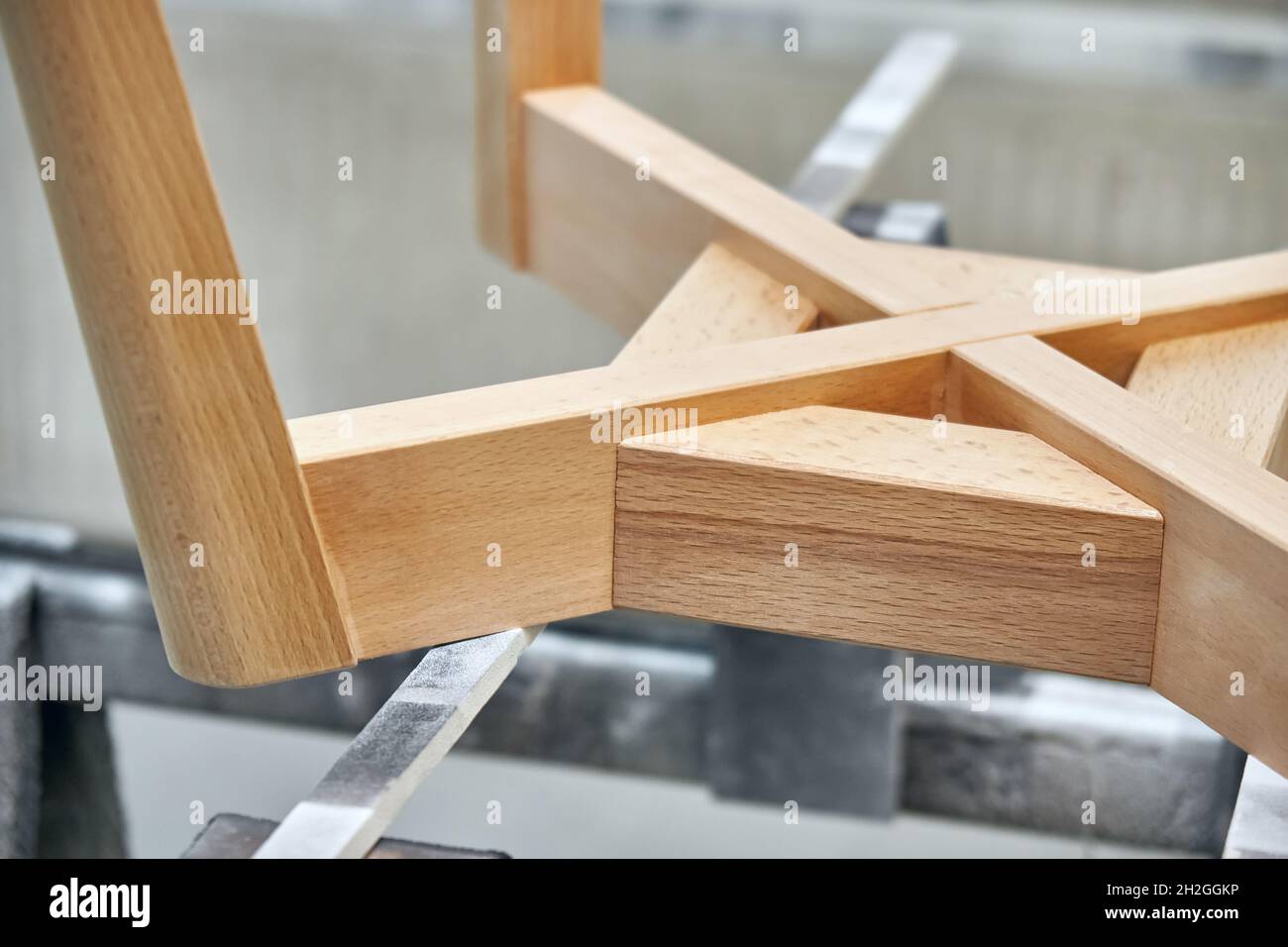 Base en bois avec pieds simples pour l'assemblage de chaises élégantes dans une cabine de pulvérisation de peinture légère à la clôture de l'atelier Banque D'Images