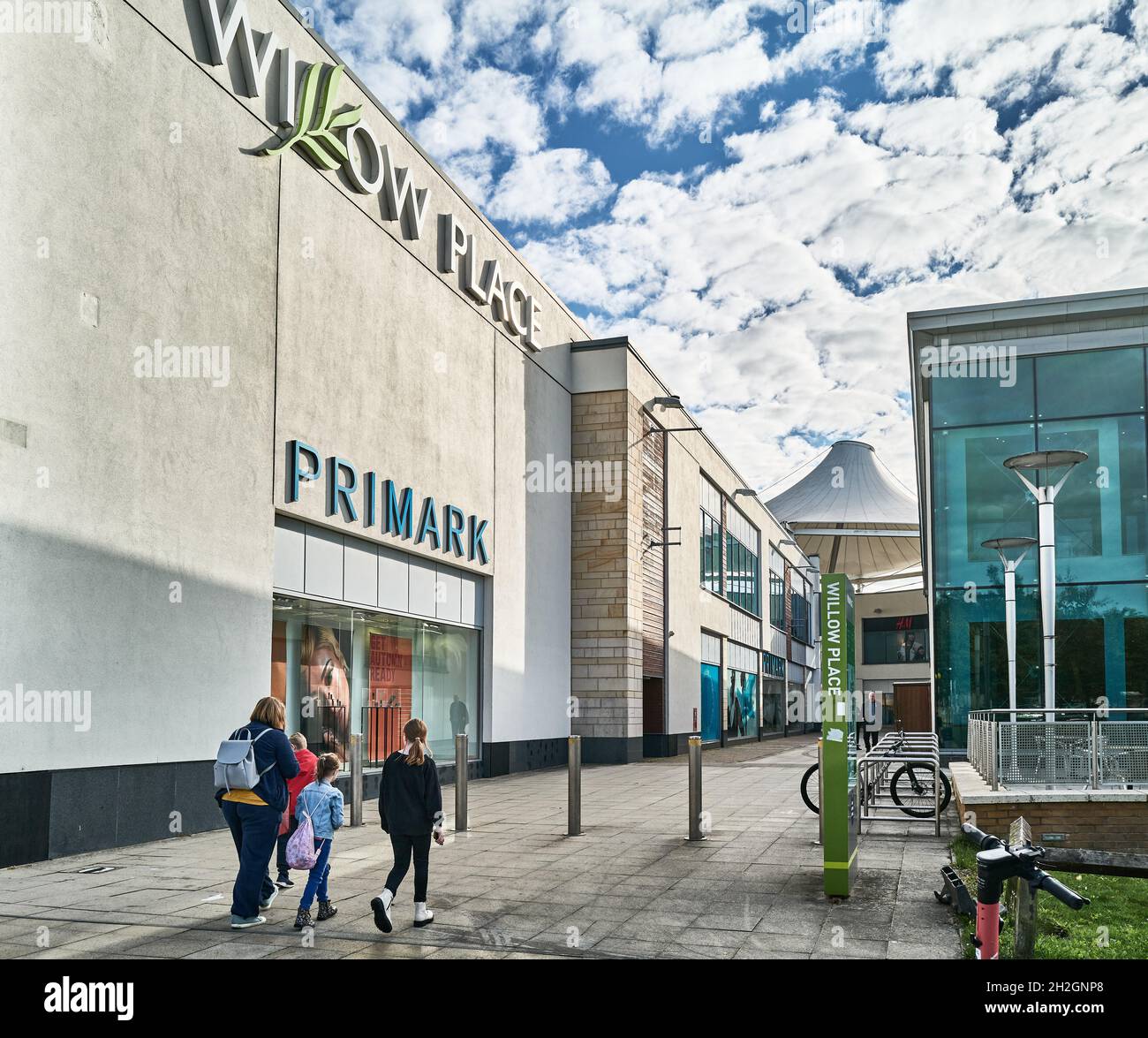 Une famille de mère et trois enfants entrent dans le complexe commercial Willow place au centre-ville de Corby, en Angleterre. Banque D'Images