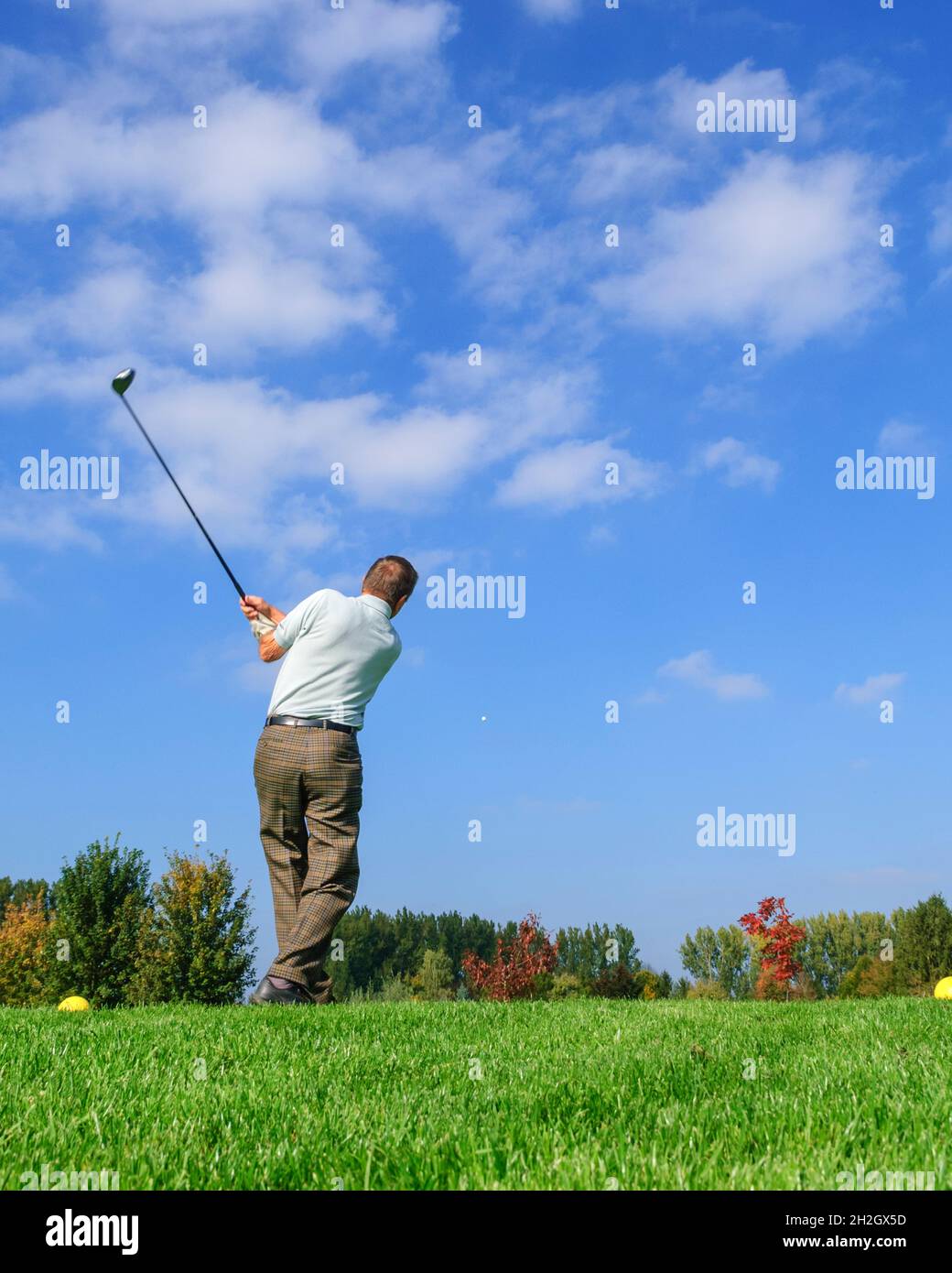 Un joueur de golf plus âgé frappe la balle du tee Banque D'Images