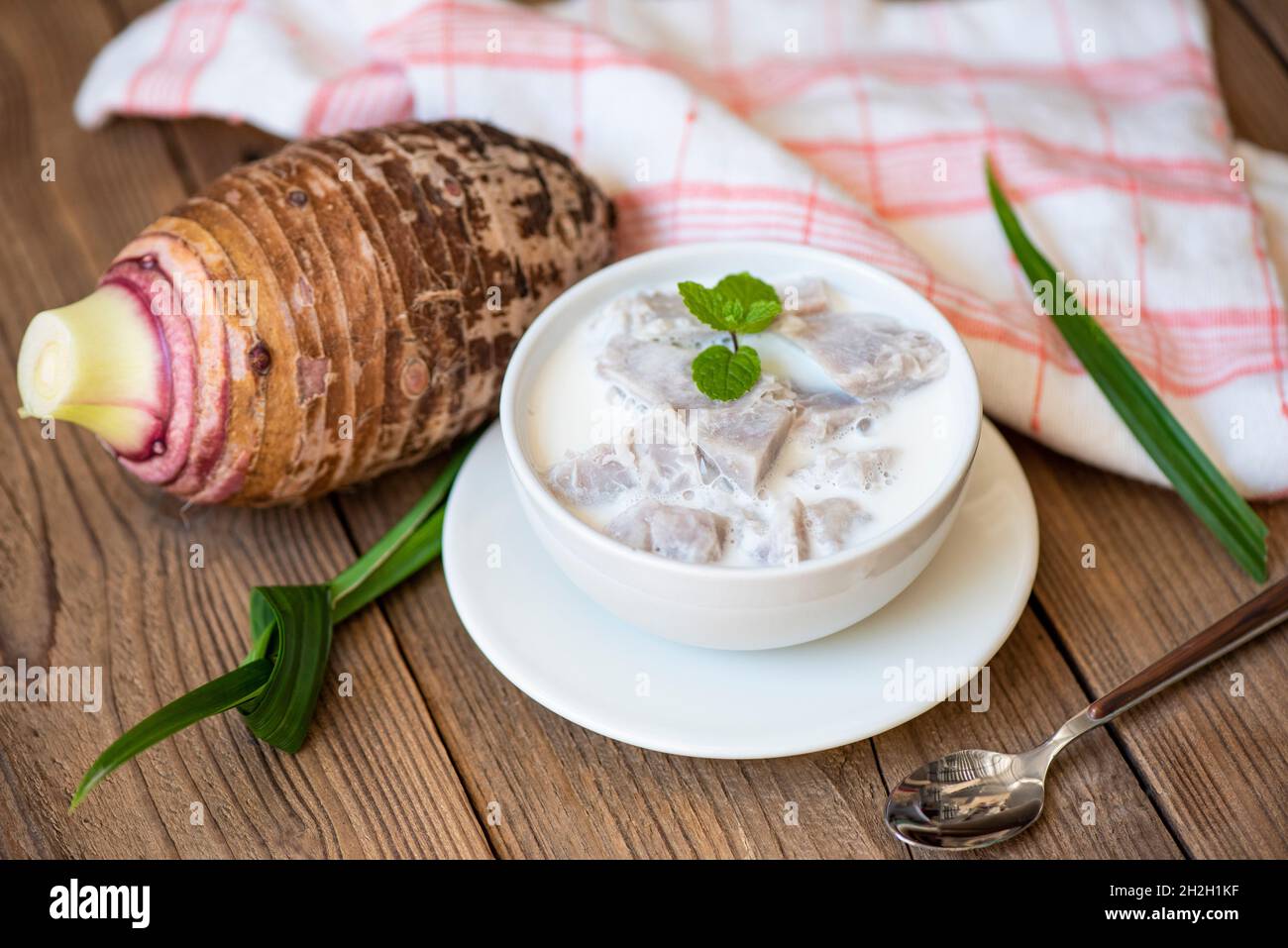 Taro alimentaire avec dessert taro bouilli avec du sucre et du lait de coco sur un bol et de la racine de taro frais cru bio prêt à cuire, cuisine thaïlandaise asiatique Banque D'Images