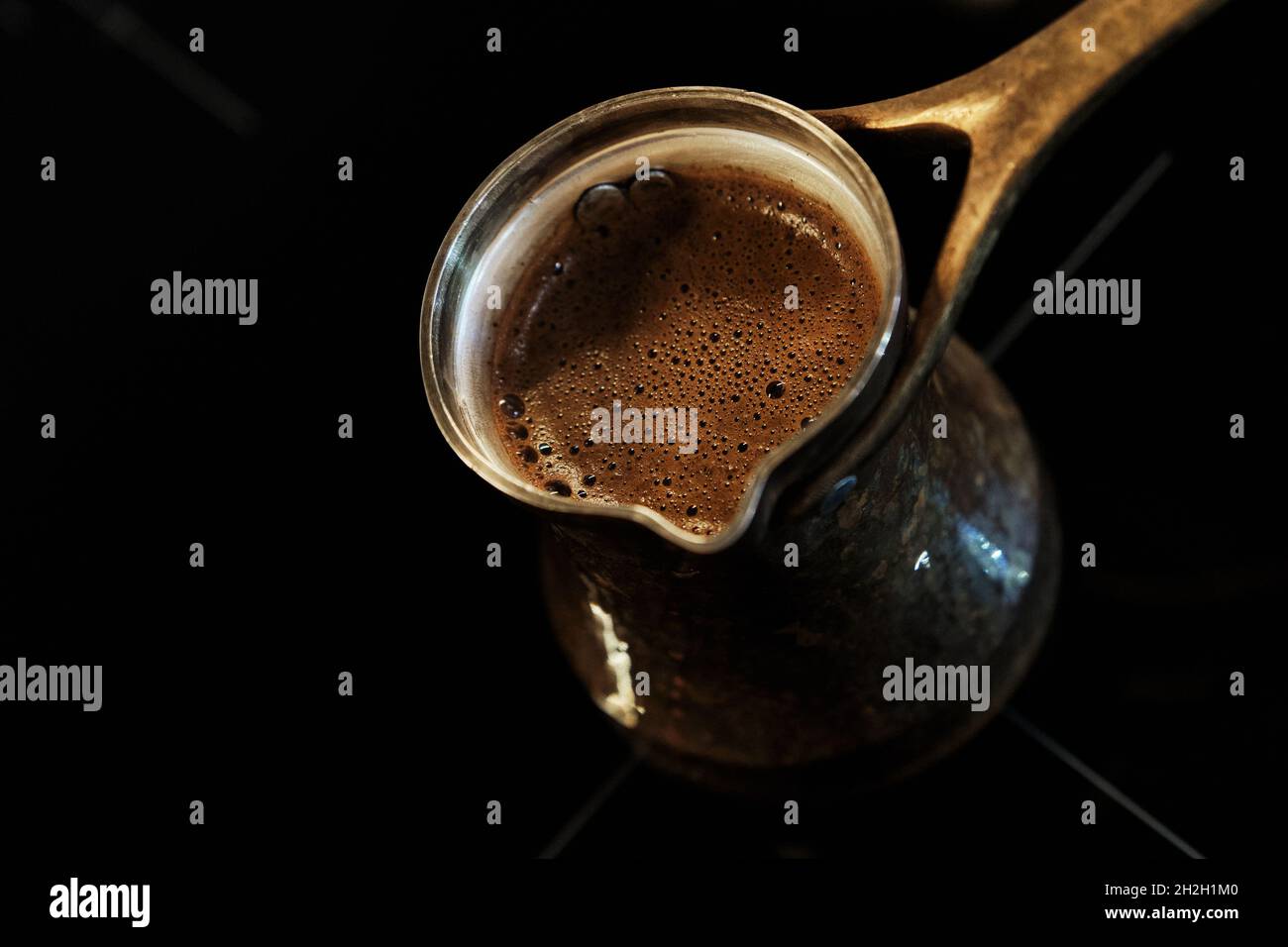 Café chaud frais dans une glace en cuivre sur une surface noire d'une  plaque à induction.Vue de dessus.Cafetière traditionnelle pour la cuisson  du café turc Photo Stock - Alamy