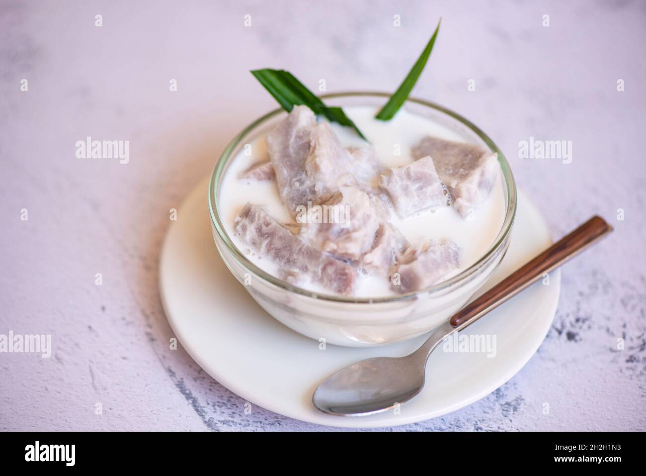 Taro alimentaire avec dessert taro bouilli avec du sucre et du lait de coco sur un bol et de la racine de taro frais cru bio prêt à cuire, cuisine thaïlandaise asiatique Banque D'Images