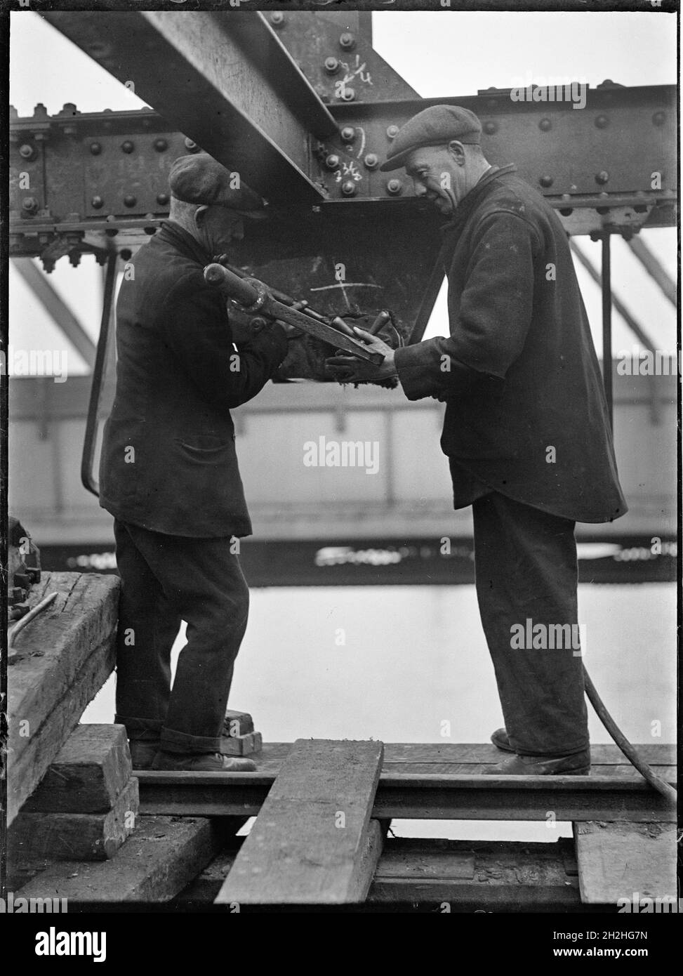 Démolition du pont Waterloo, Lambeth, Greater London Authority, 1936.Deux hommes qui travaillent sous une poutre pendant la démolition de l'ancien pont de Waterloo.Le pont de Waterloo, qui est présenté pendant sa démolition, a été conçu par John Rennie et a ouvert ses portes en 1817.La démolition du pont a eu lieu dans les années 1930 et les deux hommes illustrés démantelent un cadre temporaire en acier qui avait été érigé en 1925.Le pont a par la suite été remplacé par un autre dans les années 1940. Banque D'Images