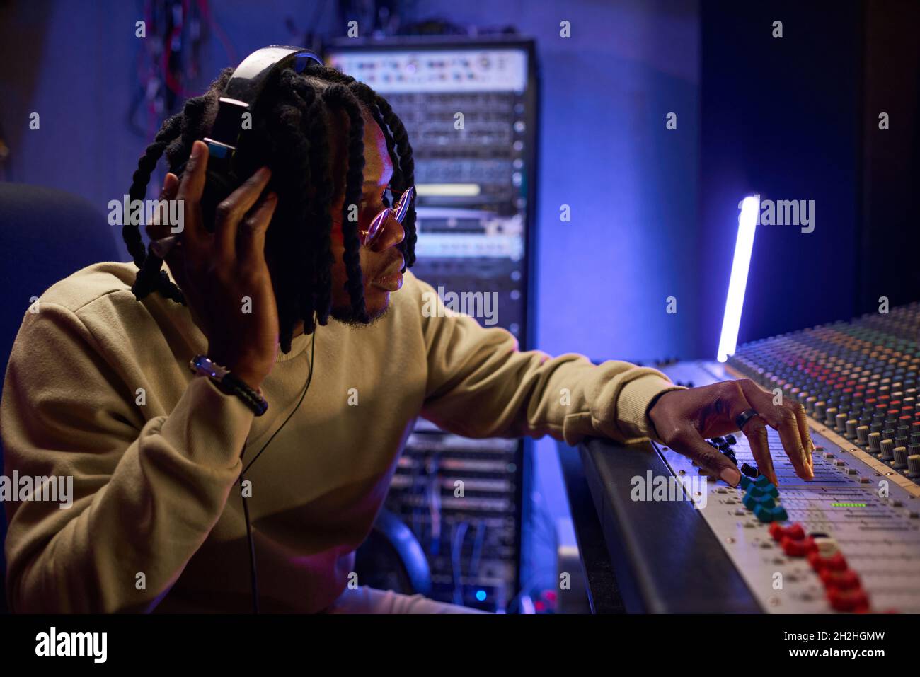 Arrangeur de musique masculin composant une chanson sur piano midi et équipement audio dans un studio d'enregistrement numérique Banque D'Images