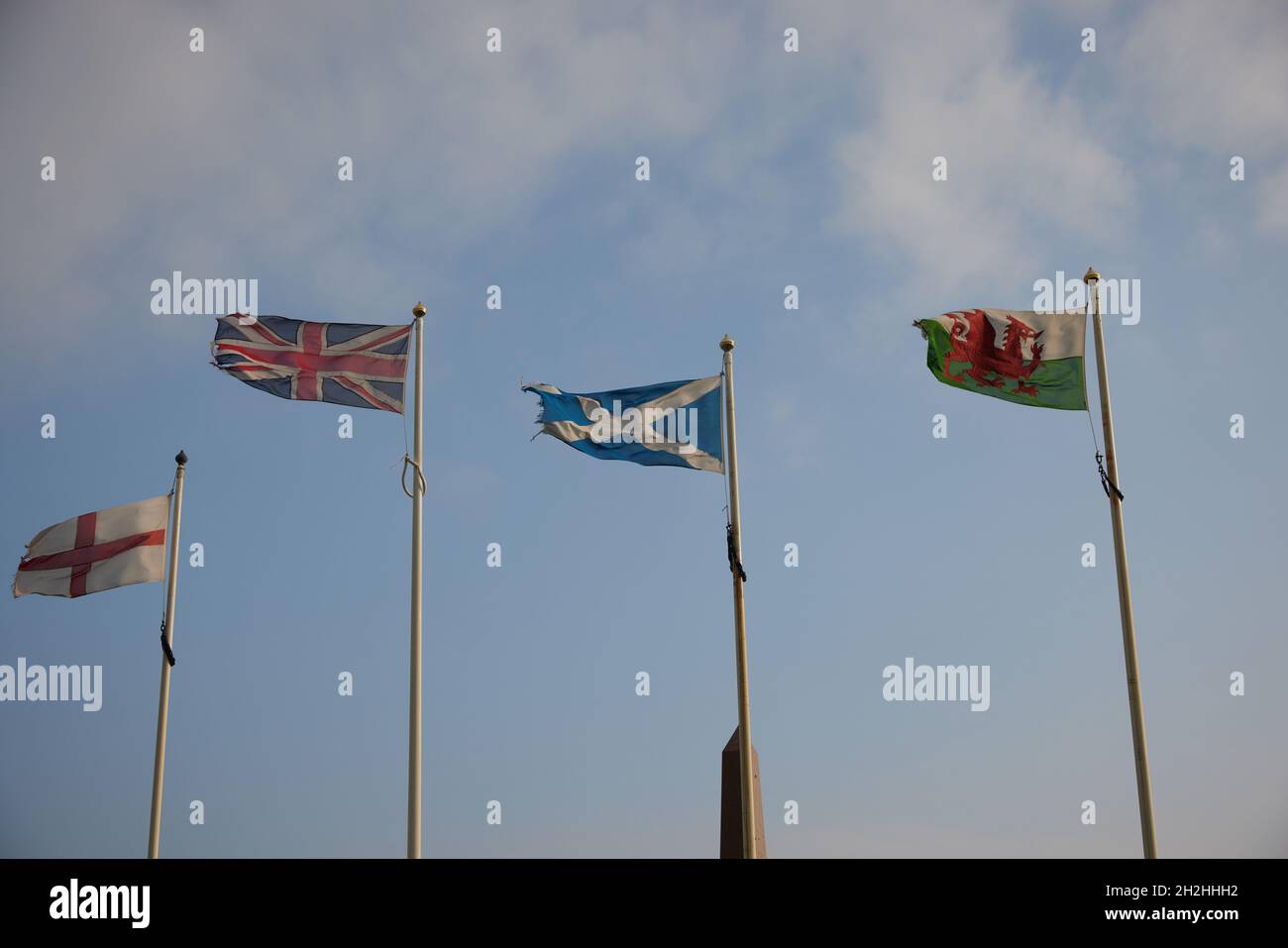 Les drapeaux nationaux du Royaume-Uni, de l'Écosse, de l'Angleterre et du pays de Galles ont vu voler sur des mâts de drapeaux sous un vent fort. Banque D'Images
