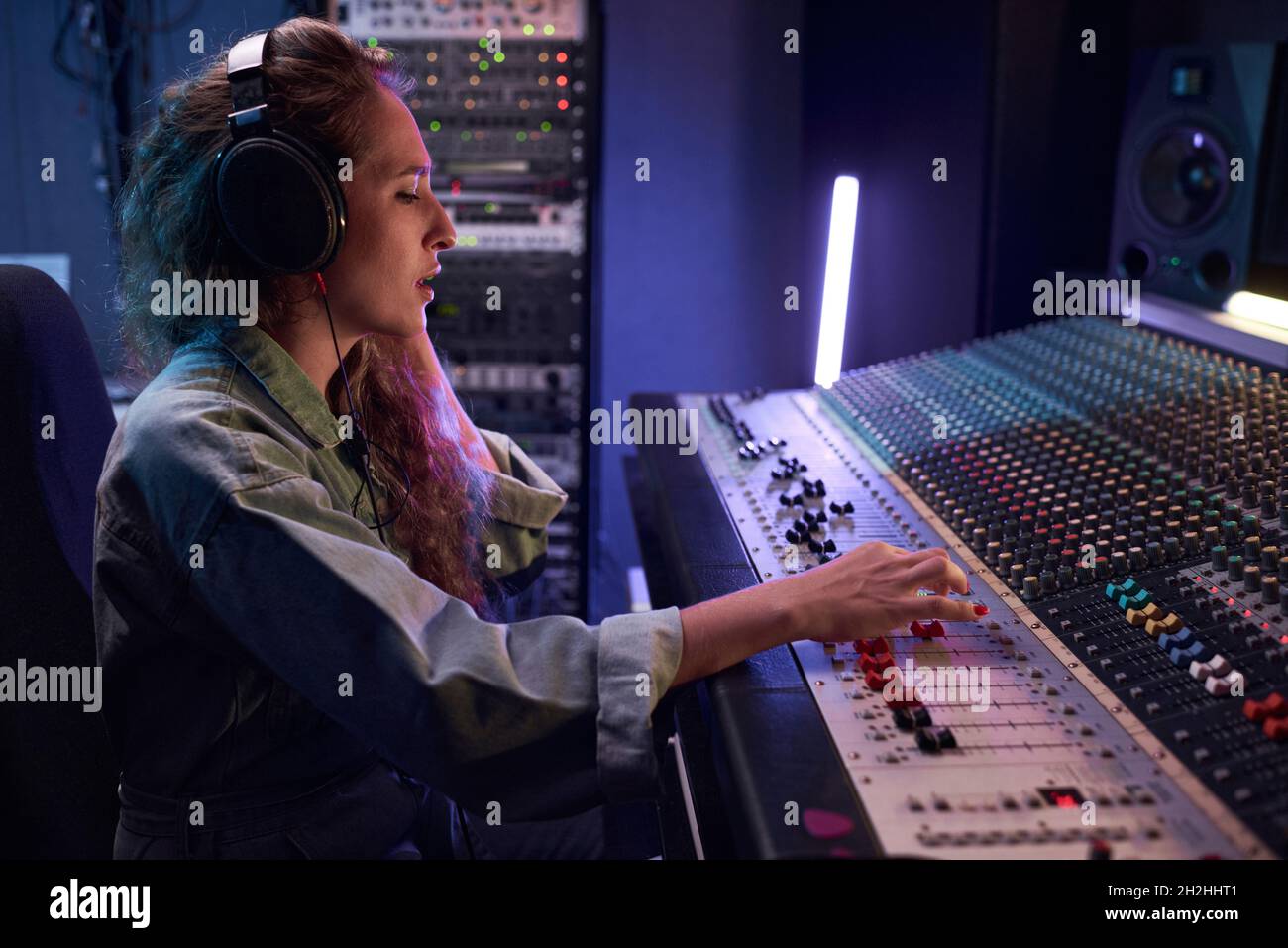 Radio DJ dans le casque à l'aide d'un clavier musical pour lire la musique pendant la diffusion Banque D'Images