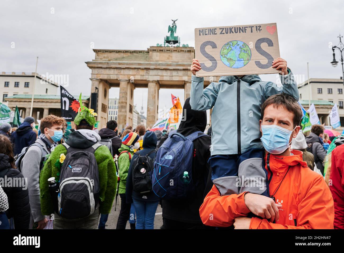 22 octobre 2021, Berlin: 'My future SOS' est écrit sur une bannière tenue devant le visage d'un enfant alors qu'il est assis sur les épaules de son père devant la porte de Brandebourg.Des milliers de manifestants se tiennent debout avec des slogans loin dans la rue ce 17 juin.Les jours d'action, à laquelle l'alliance "Justice maintenant!"A appelé à l'occasion des négociations de coalition à Berlin, commencez ici.Outre Fridays for future, l'initiative d'expropriation « expropriate Deutsche Wohnen & Co. », Ende Gelände, Sea-Watch, action Alliance anti-racisme, extinction Rebellion et l'initiative Mietenwahnsinn sont également disponibles Banque D'Images