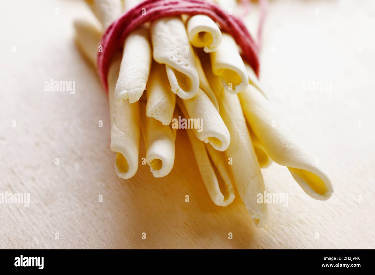 Pâtes italiennes appelées macheroni calabresi sur fond de bois, pâtes longues et épaisses faites avec de la semoule de blé dur et de l'eau, pâtes typiques de Calabre Banque D'Images