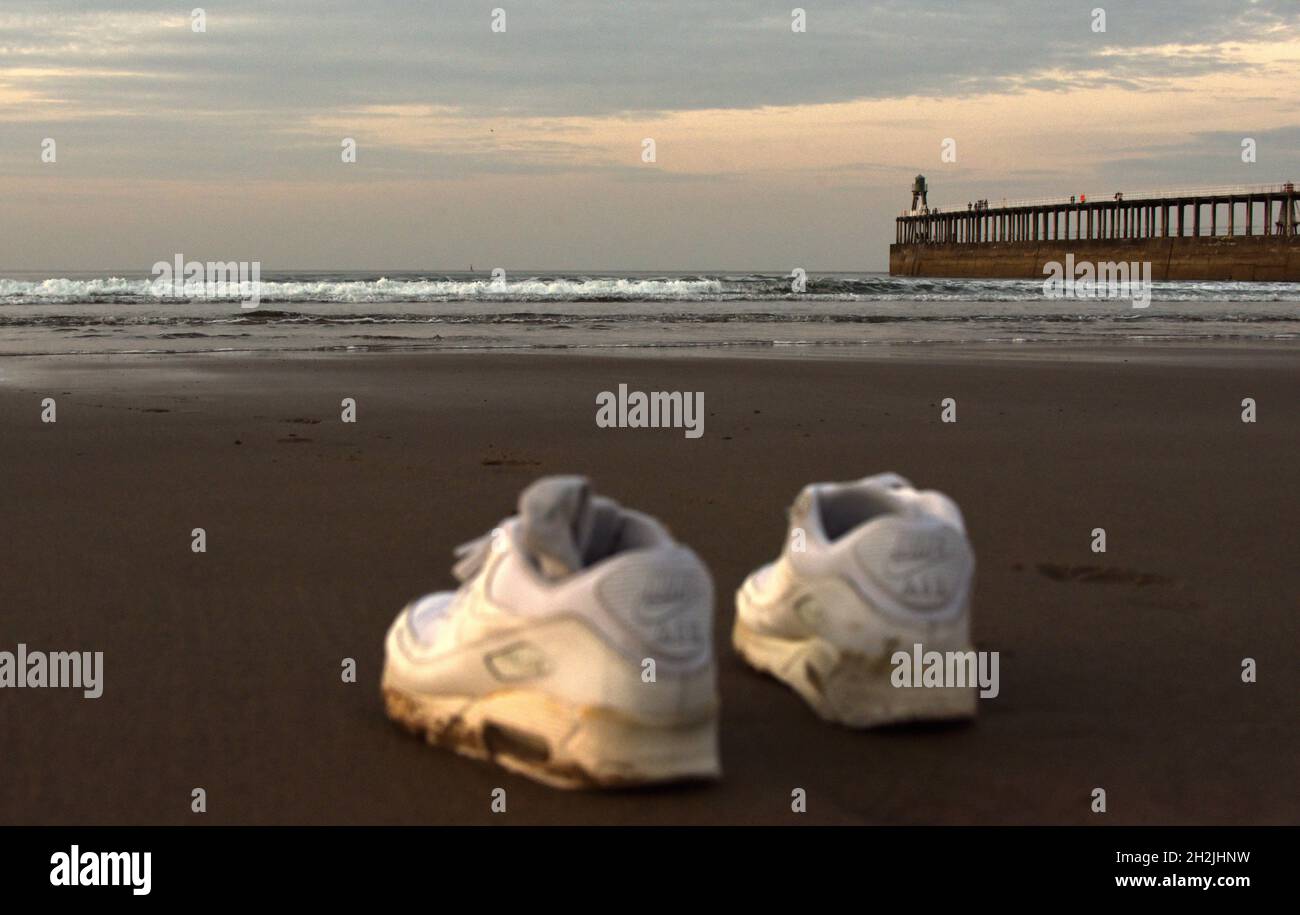 Une paire de chaussures sur une plage au crépuscule à Whitby Banque D'Images