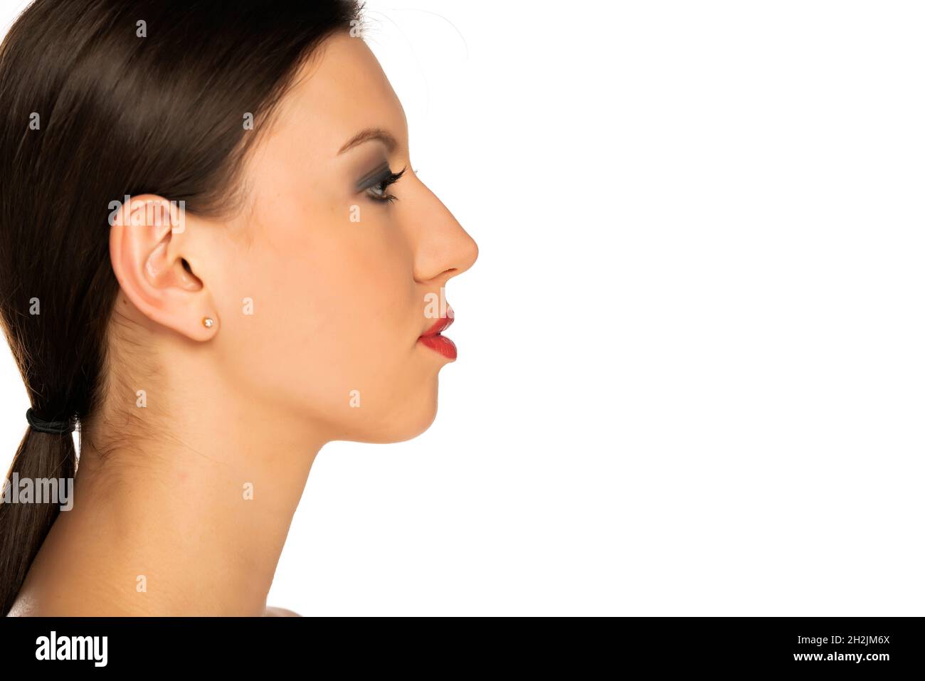 profil d'une jeune belle femme sérieuse sur fond blanc Banque D'Images