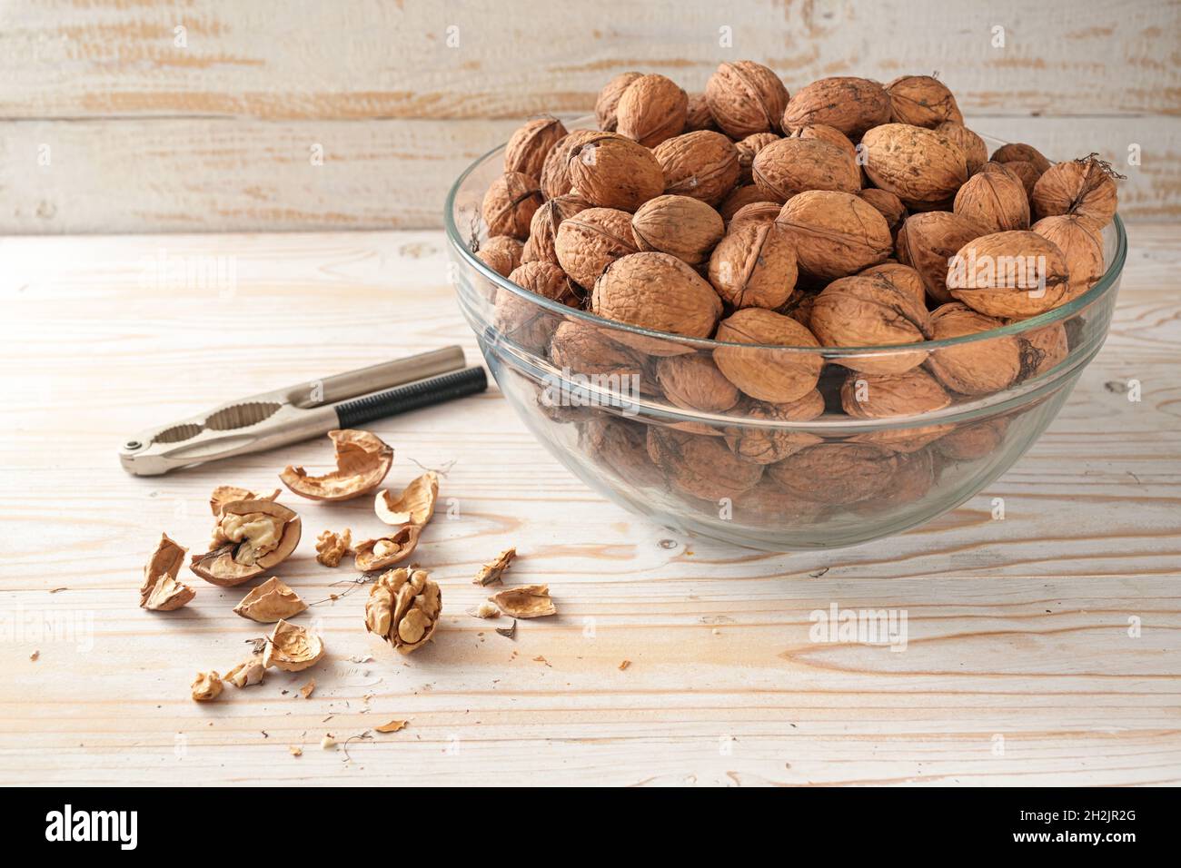 Noix d'automne bio dans un bol, entier et fissuré, alimentation saine de cerveau avec des vitamines, acides gras insaturés et antioxydants, fond en bois, co Banque D'Images