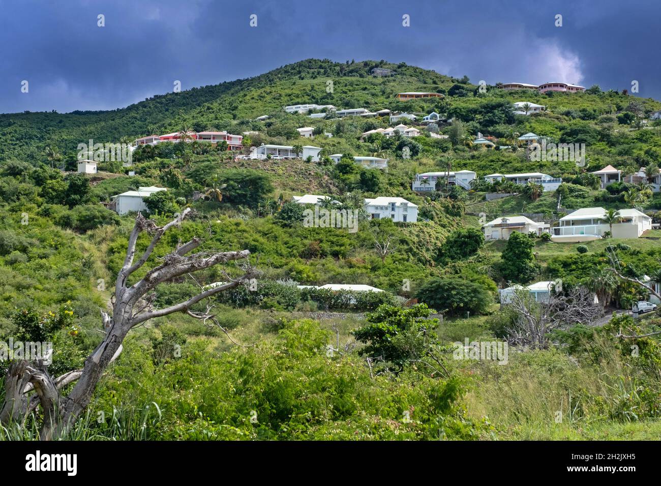 Une pluie noire menaçante se trouble sur des maisons à flanc de colline, sur le côté est de la partie hollandaise de Sint Maarten, dans la mer des Caraïbes Banque D'Images