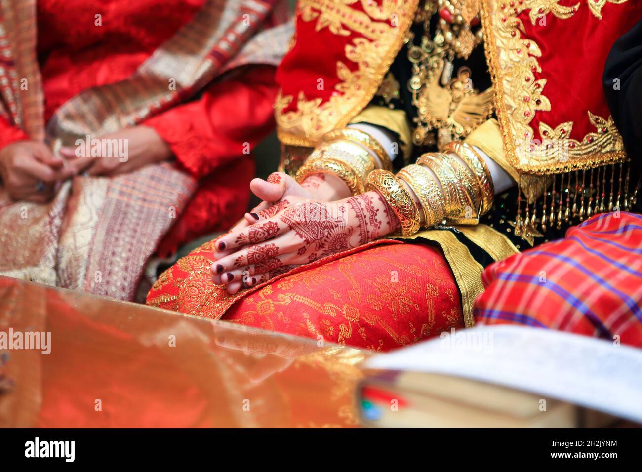 Fermez les mains et les ongles de la mariée musulmane asiatique avec tatouage de peinture de henné et bijoux dans une cérémonie traditionnelle de mariage de culture minangkabau Banque D'Images