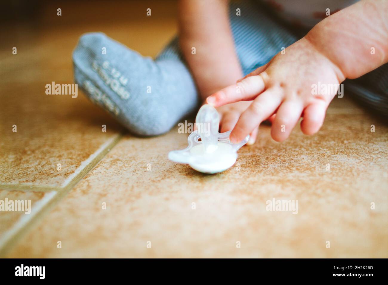 Gros plan d'un bébé touchant une sucette Banque D'Images