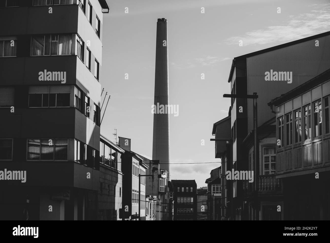 cheminée de refroidissement avec maisons de ville en premier plan en noir et blanc Banque D'Images