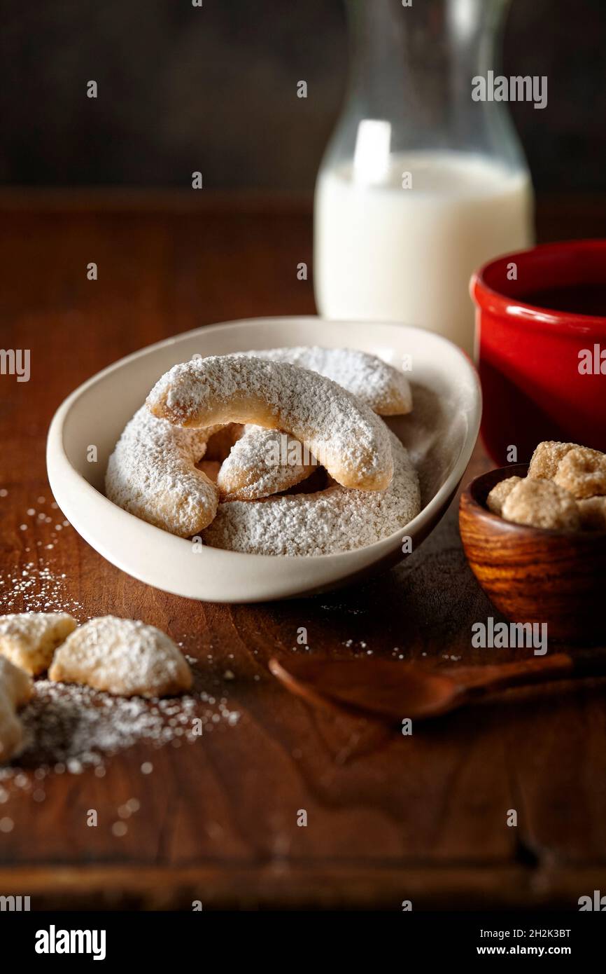 biscuits crescent dans un bol sur une surface en bois avec du café, du lait et du sucre Banque D'Images