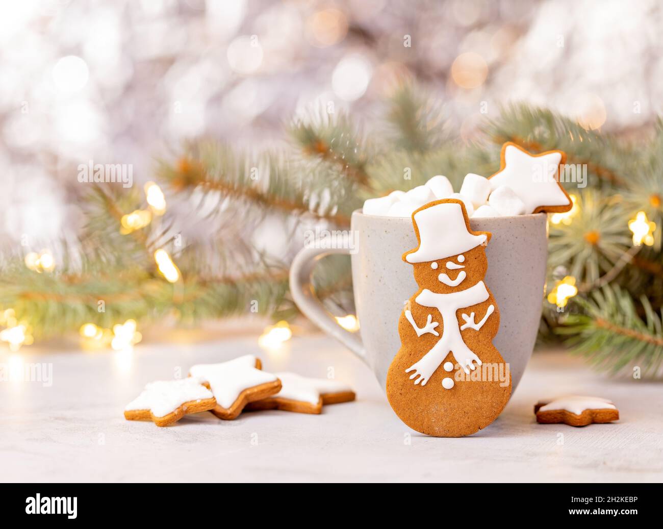 Mignon pain d'épice Snowman cookie devant une tasse de chocolat chaud avec guimauves.Arrière-plan joli bokeh. Banque D'Images