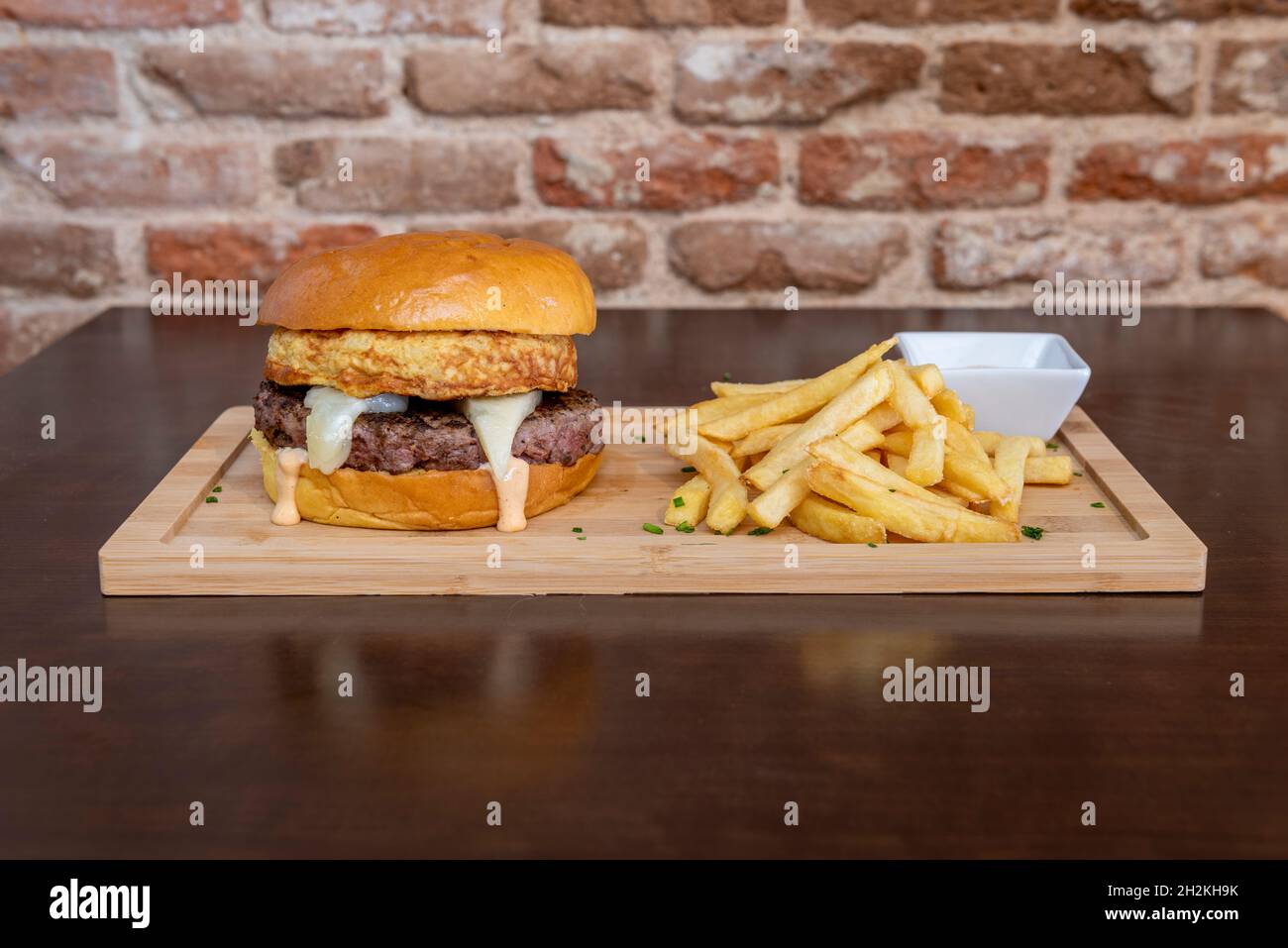 hamburger avec bœuf, mini omelette espagnole, fromage Manchego, salsa, frites et ciboulette Banque D'Images