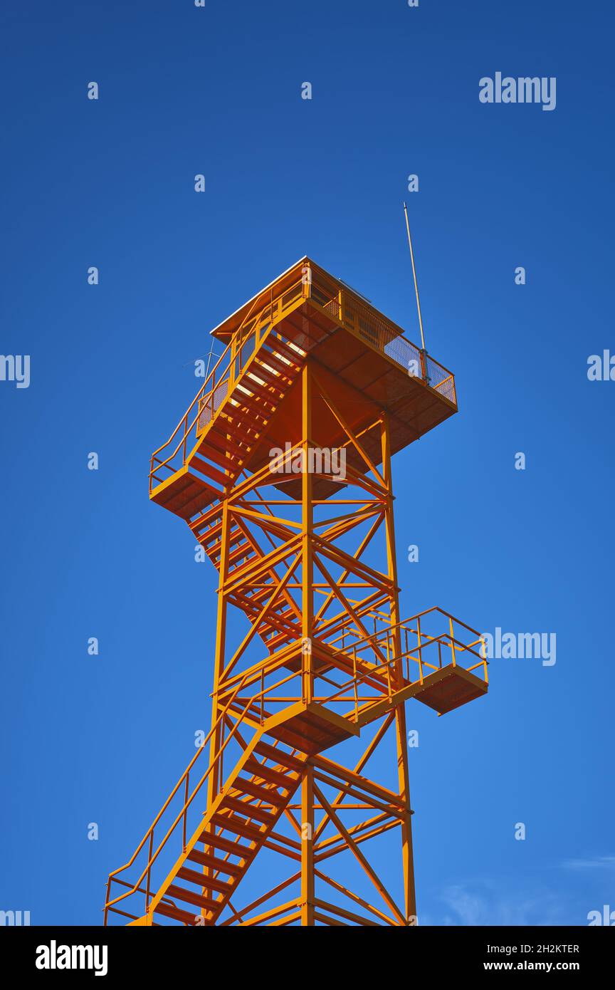 détail d'une tour d'observation des incendies en métal orange avec un ciel bleu Banque D'Images