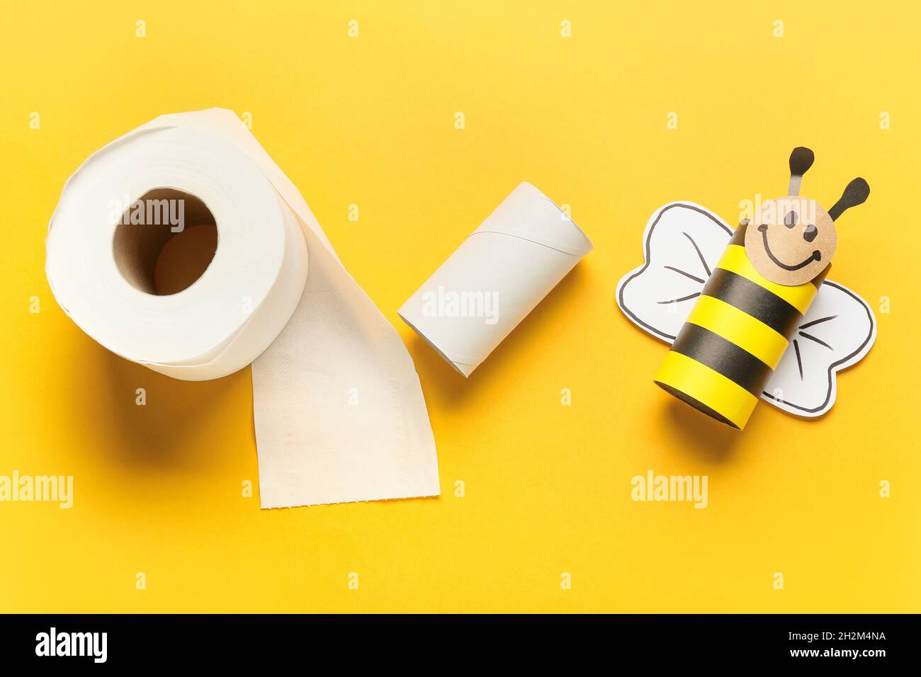 Abeille en carton, rouleau de papier hygiénique et tube vide sur fond jaune  Photo Stock - Alamy