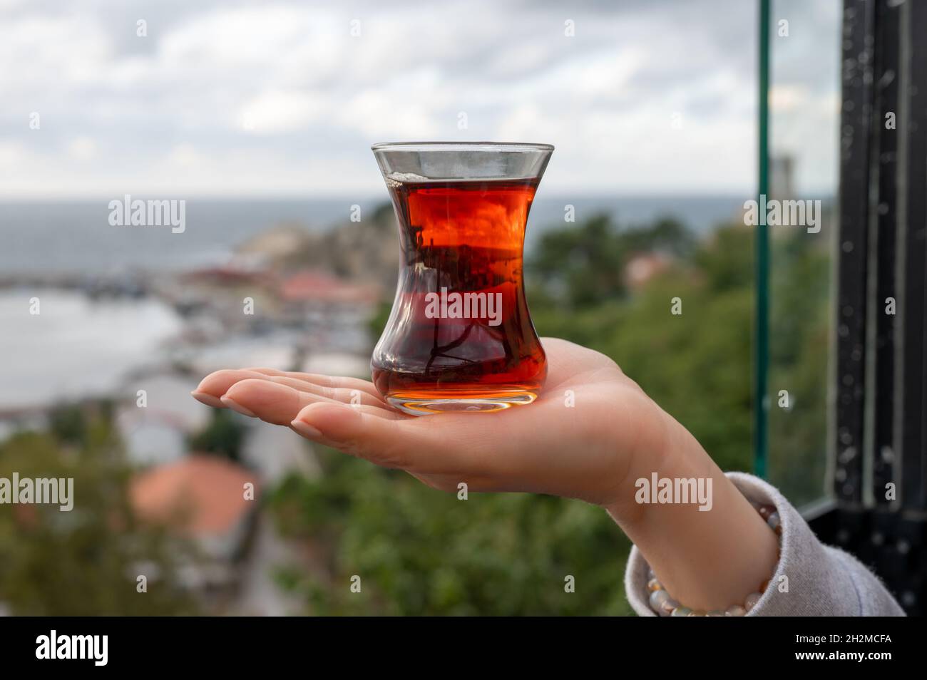 Tasse de thé armudas à la main de femme, thé turc traditionnel thé turc rouge aromatique dans la traditionnelle tasse de verre authentique - armudu Banque D'Images