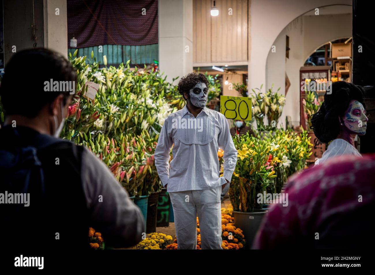 Mexiko Stadt, Mexique.19 octobre 2021.Omar, composé comme un squelette, se tient devant un stand de fleurs au marché traditionnel 'Jamaïque' avant le jour des morts.Au Mexique, c'est une fête contemplative.Pour elle, les autels sont érigés et décorés dans des maisons et des appartements.(À dpa "entre tradition et marketing: La réinvention du jour des morts") Credit: Jair Cabrera Torres/dpa/Alay Live News Banque D'Images