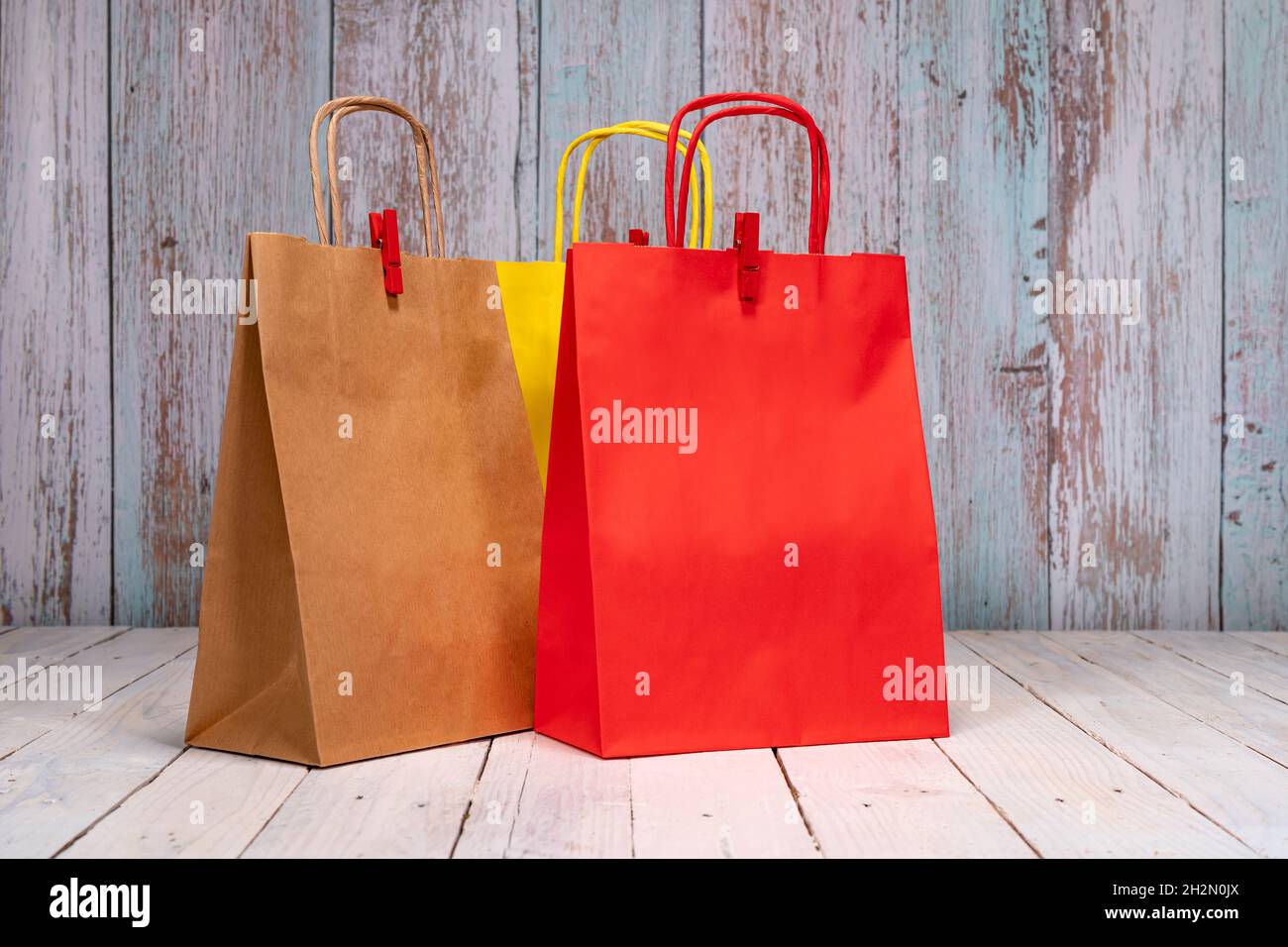 Des sacs en papier colorés sur une table en bois chic et chic pour vos  achats joyeux.Espace pour le logo ou l'écriture sur le sac rouge et marron  Photo Stock - Alamy