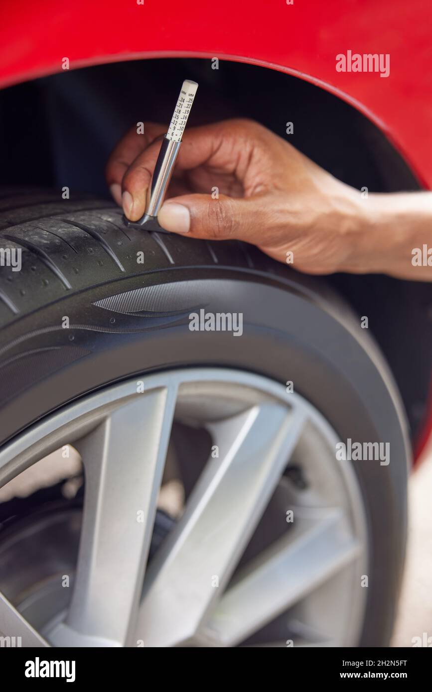 Portrait de l'homme Contrôle de la voie sur pneu de voiture avec manomètre Banque D'Images