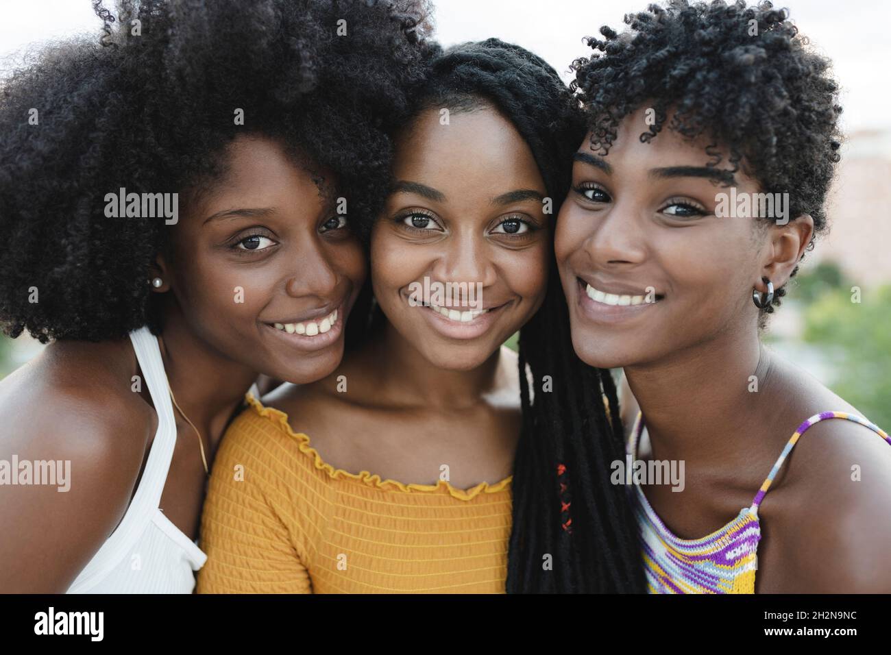 Des amies souriantes qui regardent les épaules Banque D'Images