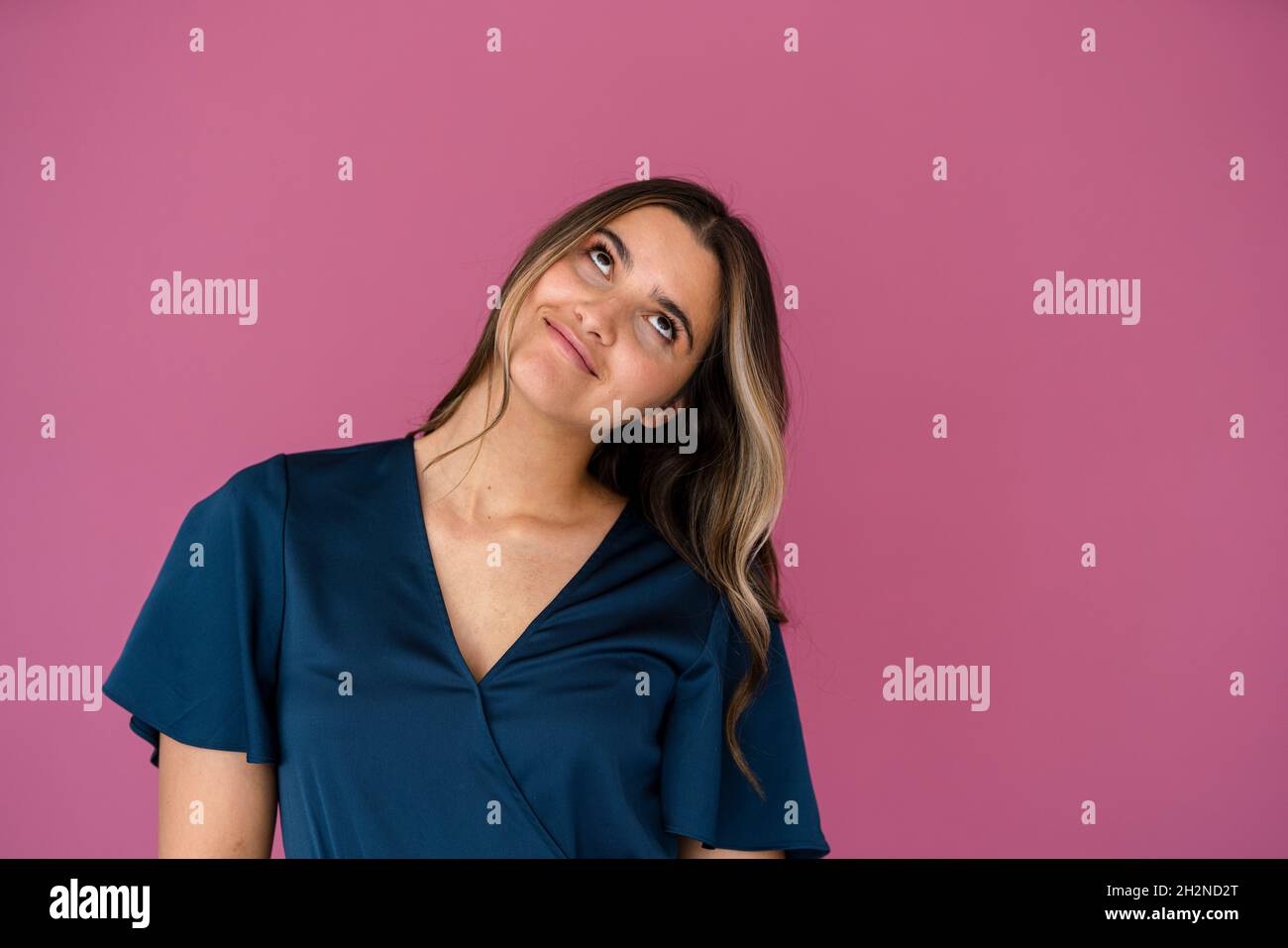 Femme d'affaires réfléchie devant un mur de couleur rose Banque D'Images
