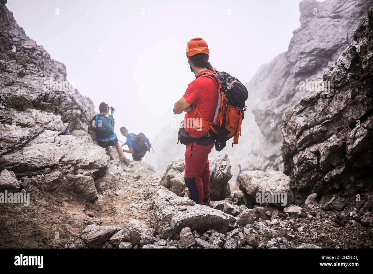 Randonneurs mâles avec randonnée à dos en montagne Banque D'Images