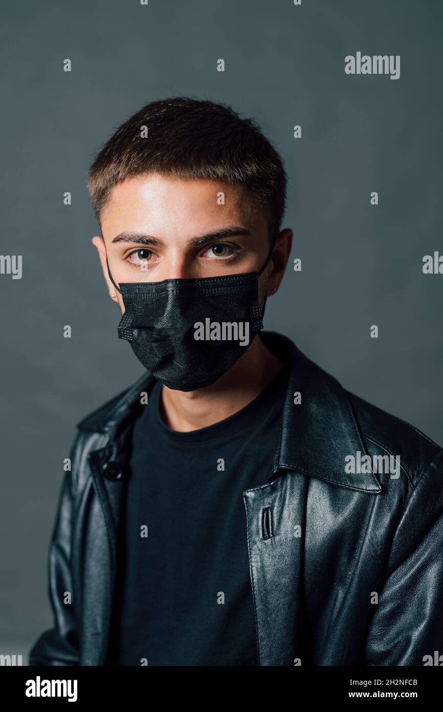 Jeune homme portant un masque de protection en studio Banque D'Images