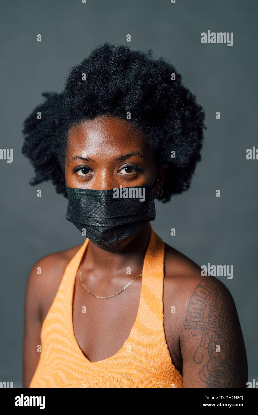 Femme afro avec masque de protection pendant COVID-19 Banque D'Images