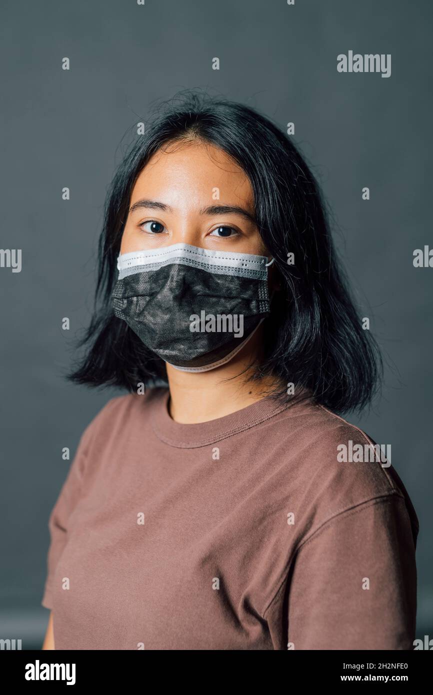 Jeune femme portant un masque protecteur pendant une pandémie Banque D'Images