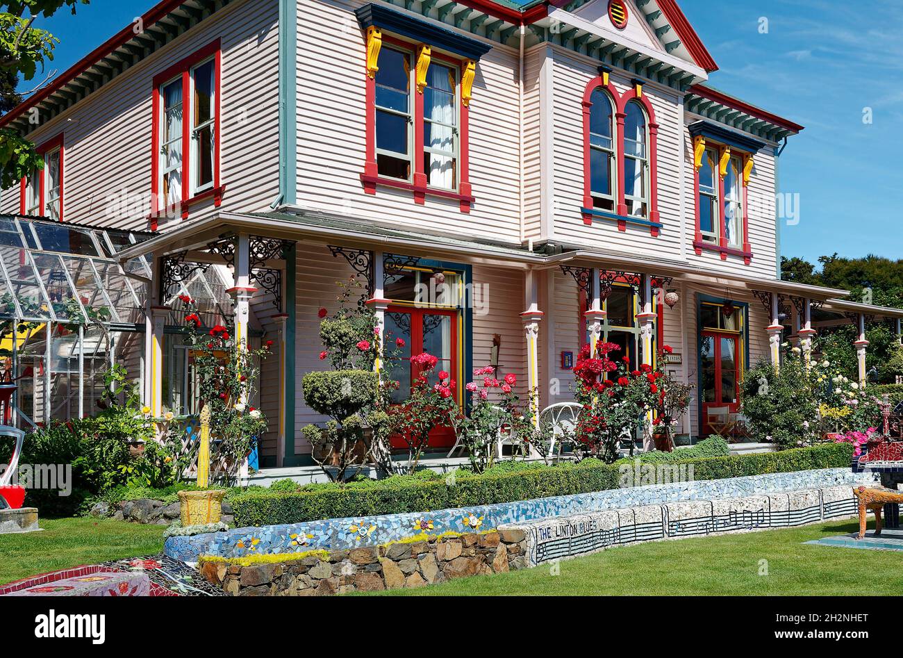 maison colorée, jardin; fleurs, banc de mosaïque, notes musicales,Imaginatif; ancien bâtiment, serre, la maison des géants; Akaroa;Nouvelle-Zélande Banque D'Images