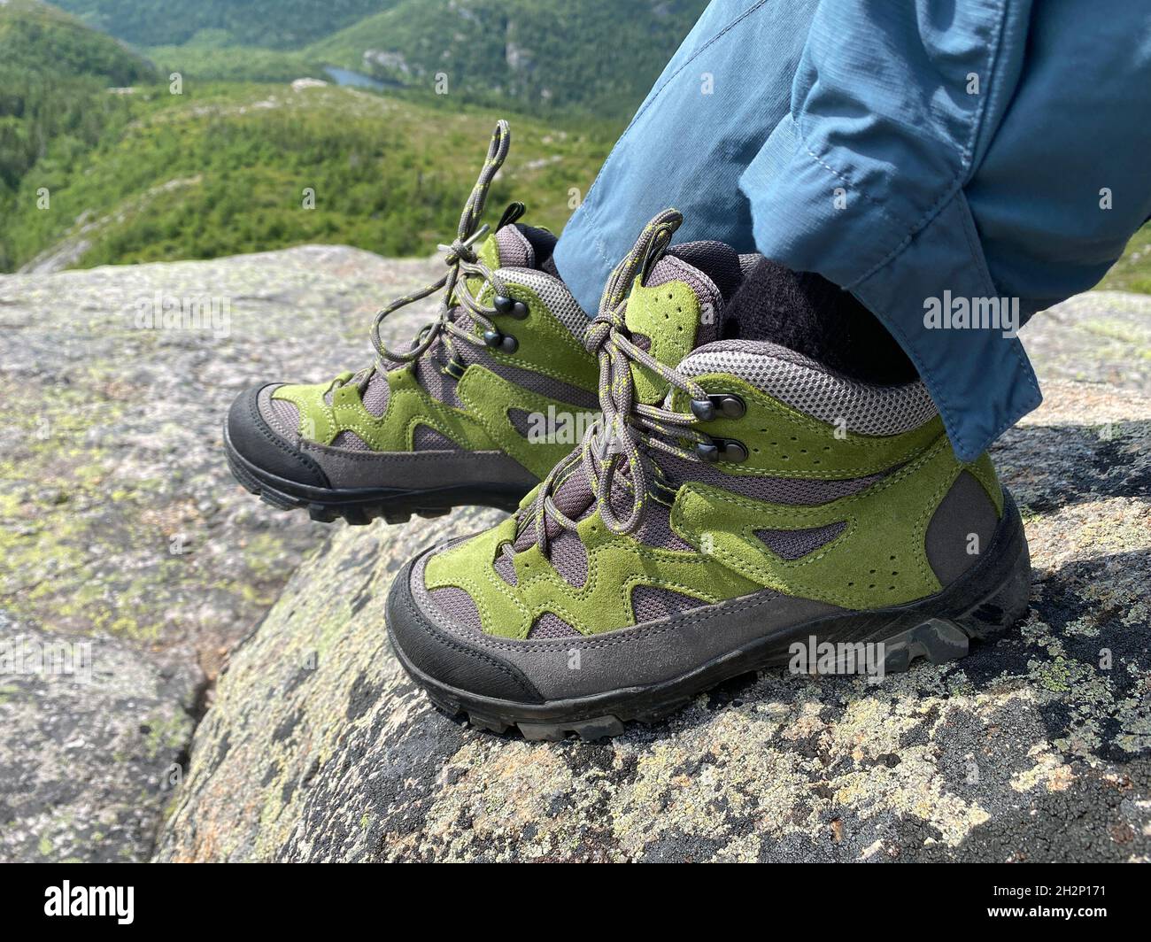 Randonnées pédestres en gros plan sur la montagne rocheuse avec forêt verte et lac en arrière-plan, Québec, Canada Banque D'Images