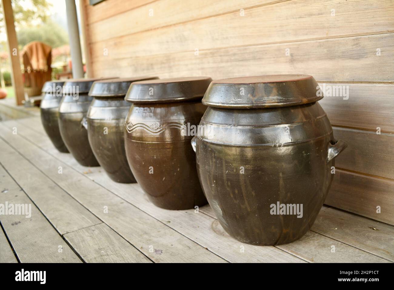 Crock traditionnel coréen en terre battue pour fermenter les kimchi, les cornichons, la choucroute ou d'autres légumes, à l'extérieur sur le porche, Healdsburg, Californie, États-Unis Banque D'Images