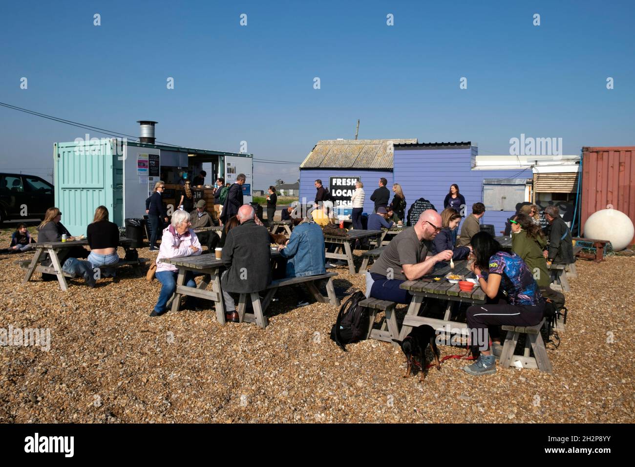 Les gens les clients assis à des tables extérieures au Dungeness Fish Hut snack Shack dans Kent Coast Angleterre Royaume-Uni Grande-Bretagne KATHY DEWITT Banque D'Images